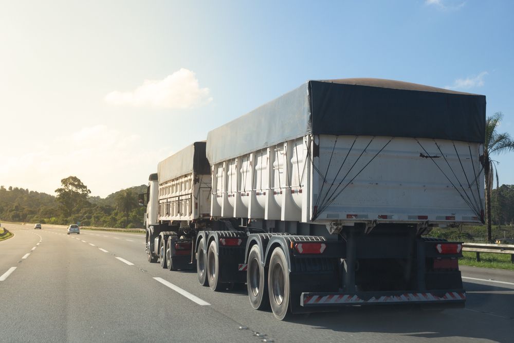 Truck With Covered Trailer Driving on a Highway, Bright Sunlight — Waite Diesel Service in Douglas, QLD