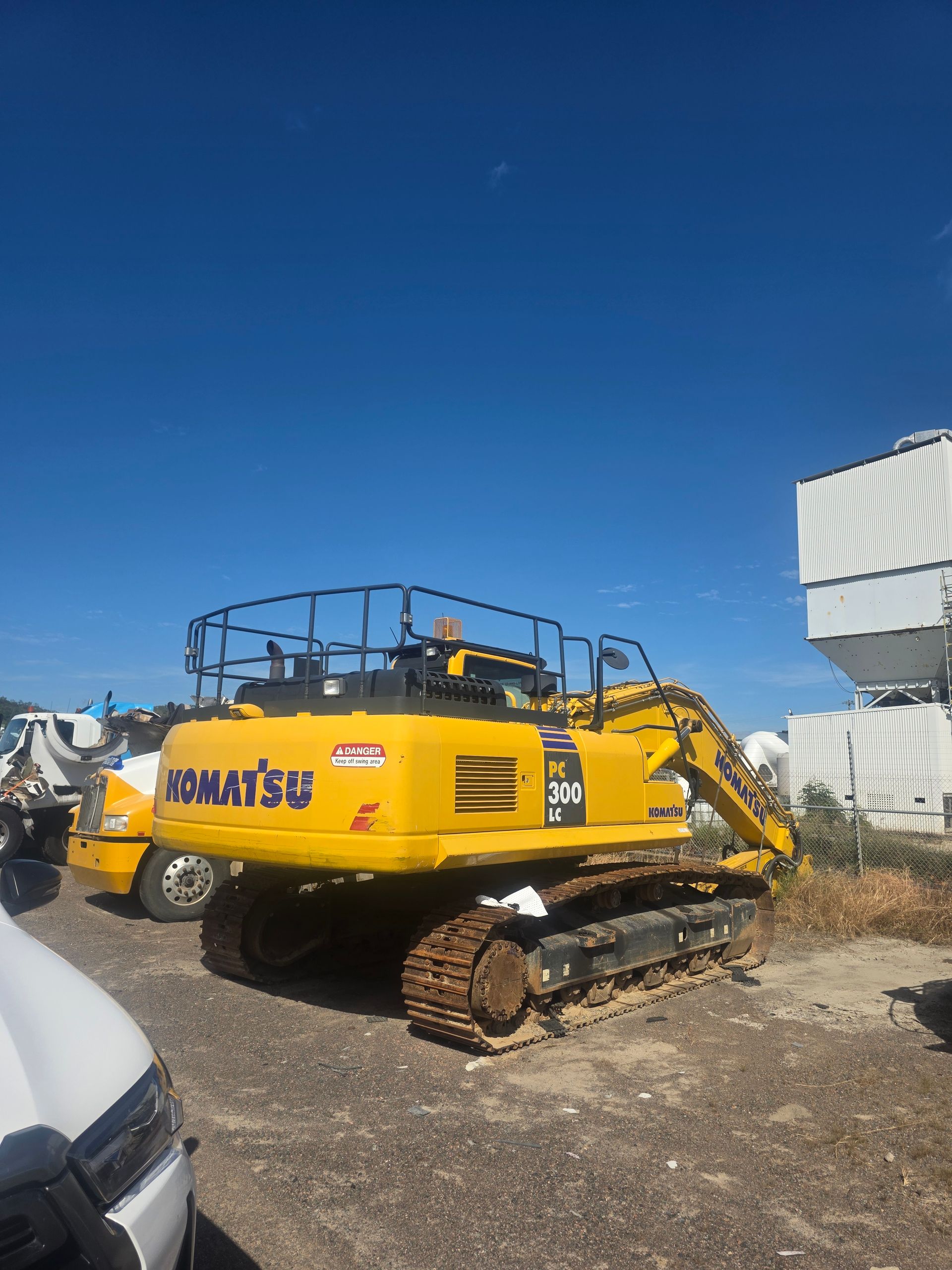 An Excavator Loading Dirt Into a Dump Truck Under a Blue Sky — Waite Diesel Service in Douglas, QLD