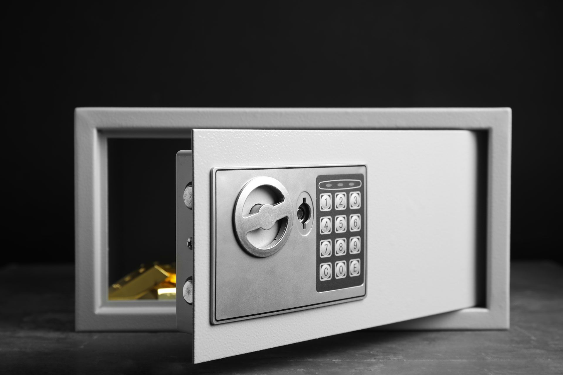 Open safe with keypad, door ajar and gold bars visible inside
