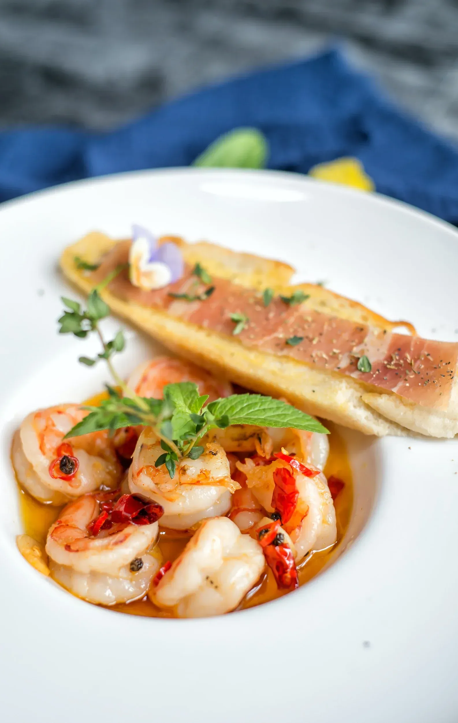 Shrimp pasta in tomato sauce with garlic bread on a white plate