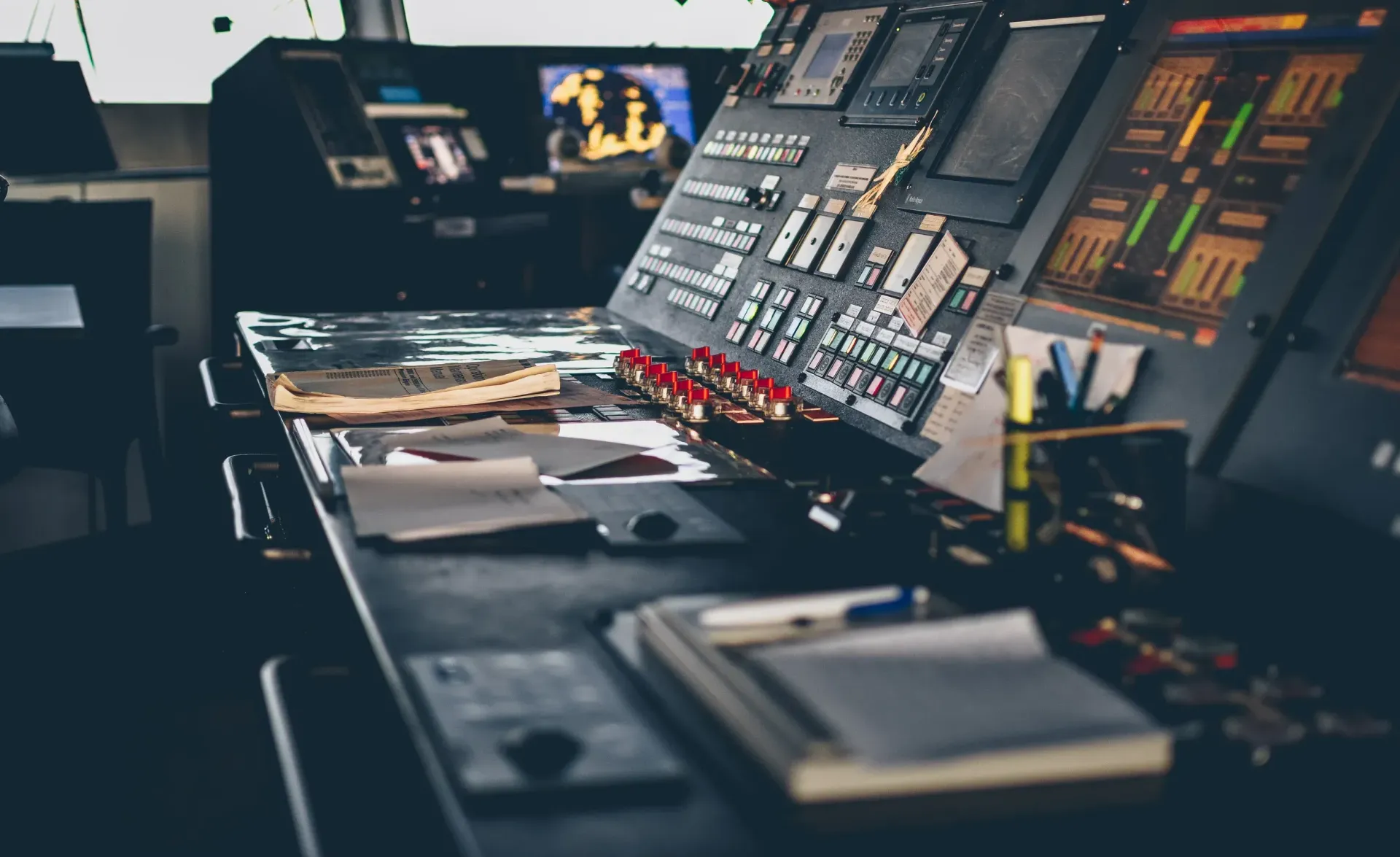 Broadcast control room with monitors, mixing consoles, and glowing equipment screens