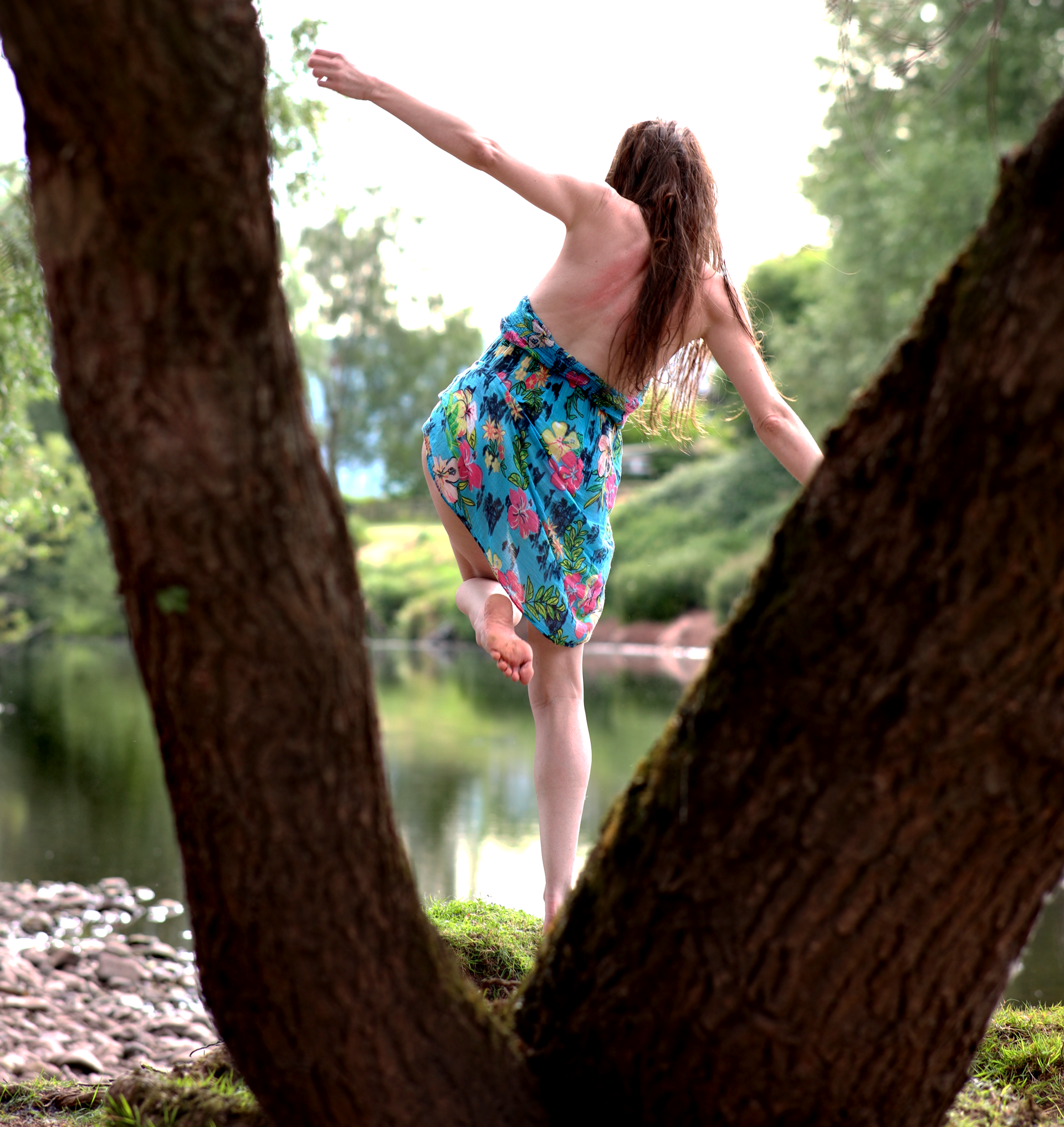 A woman in a short summer dress on a river bank.