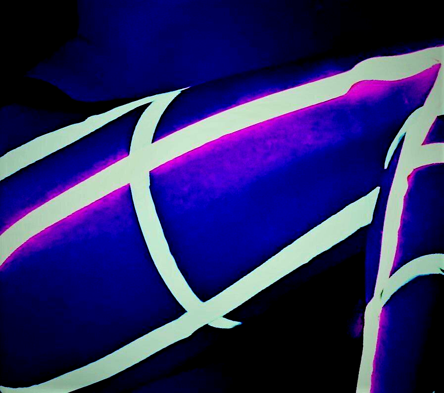 Neon tape on a woman's thigh under UV light.
