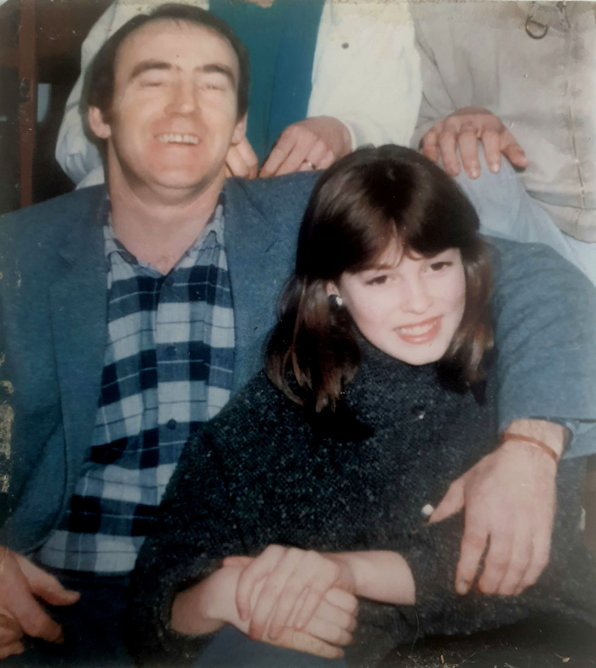 A teenage girl sitting next to her father.