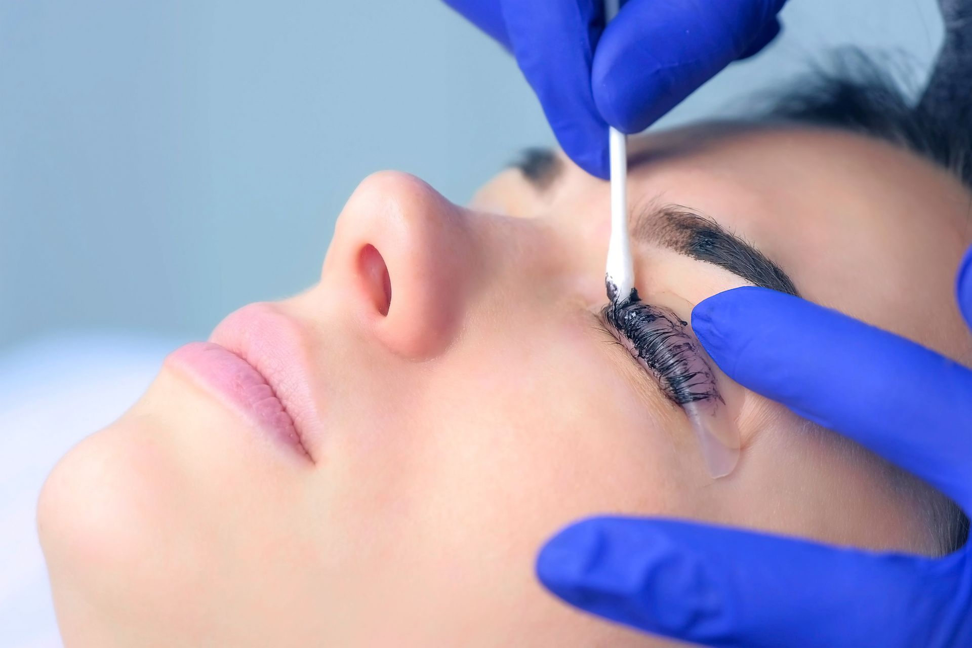 Woman receiving underarm waxing treatment at a spa.