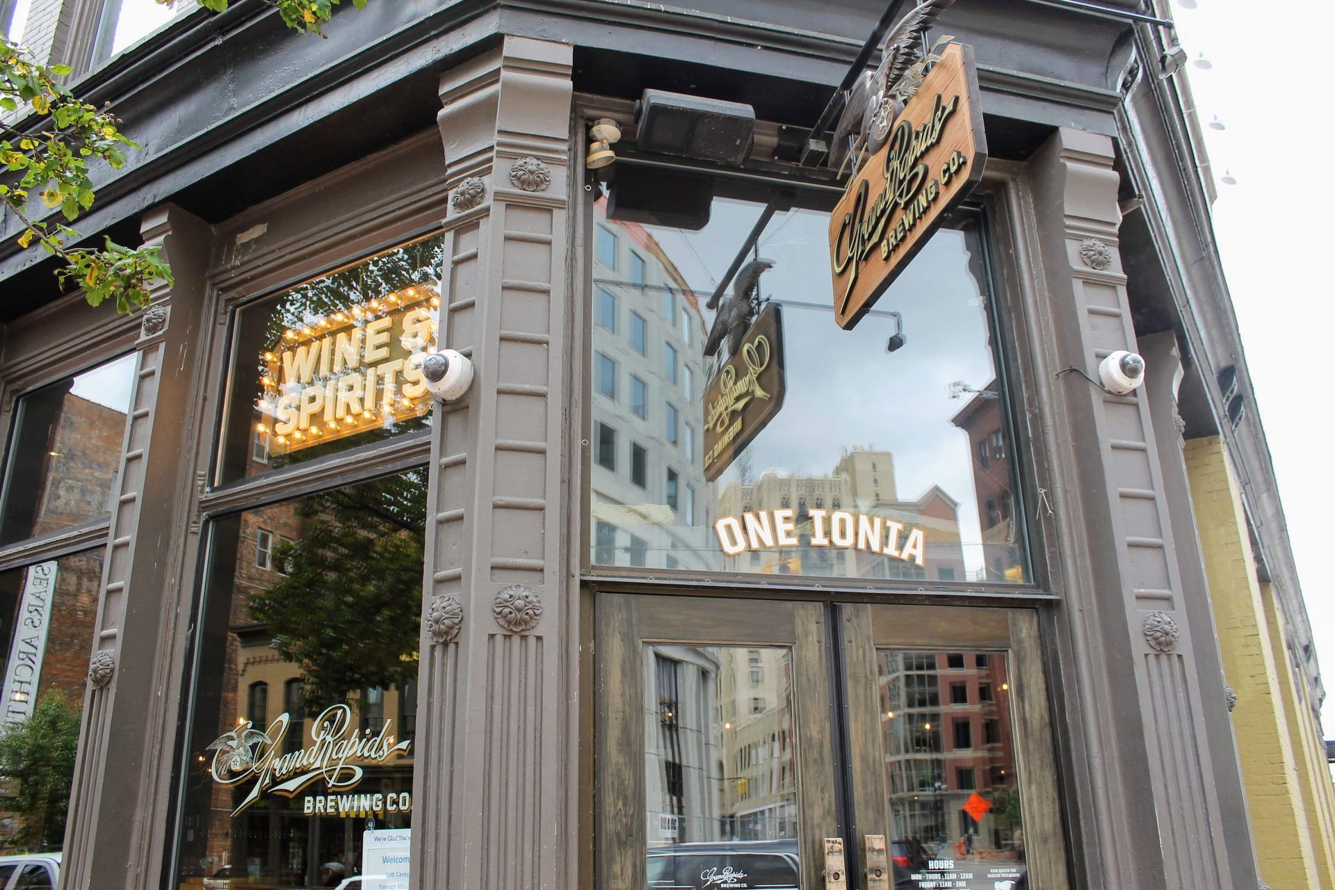 Corner storefront with reflective glass, wooden trim, and signs reading “One Tonya” and “White Witch.”