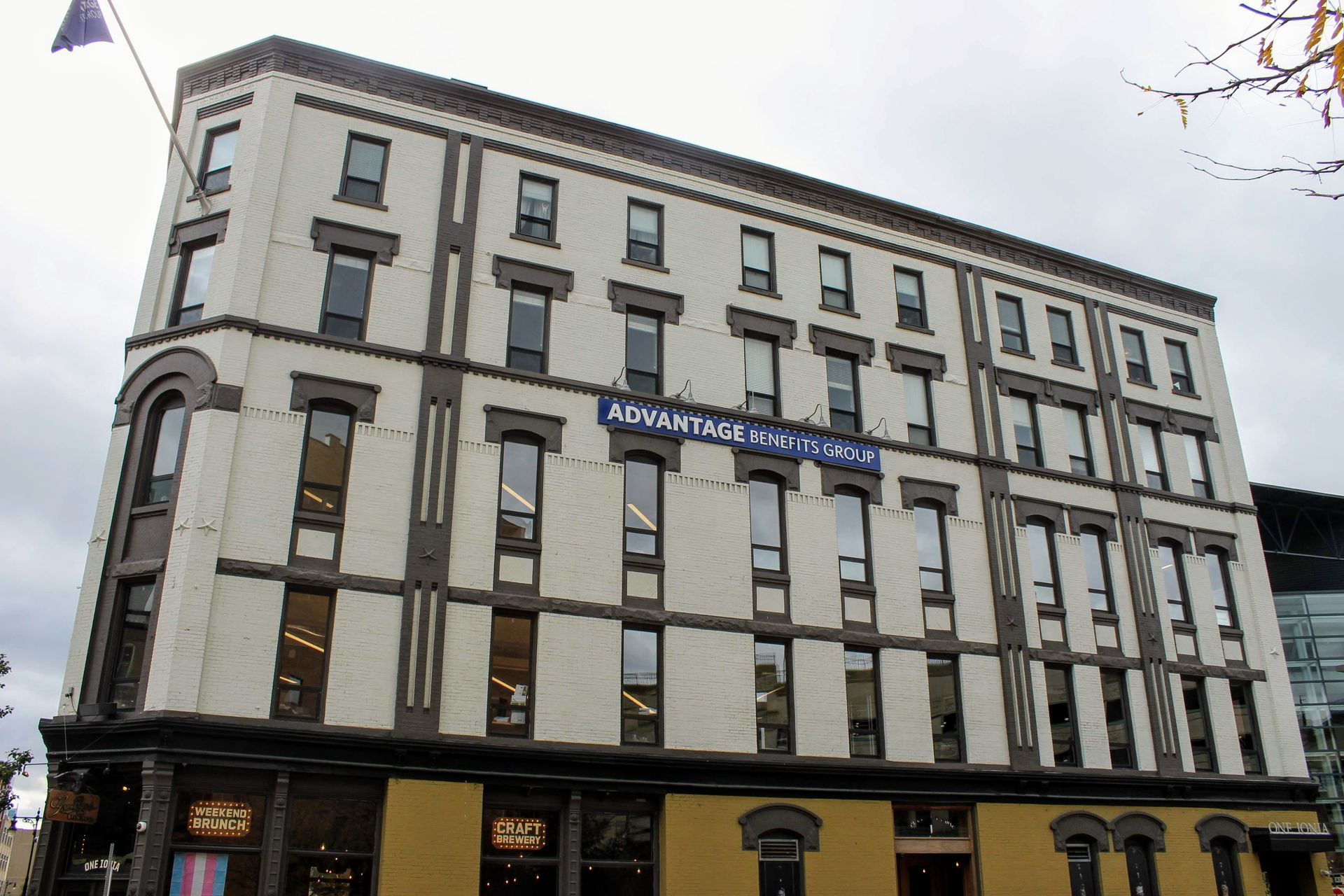 Multi-story beige hotel building with rows of windows and a blue sign above the entrance