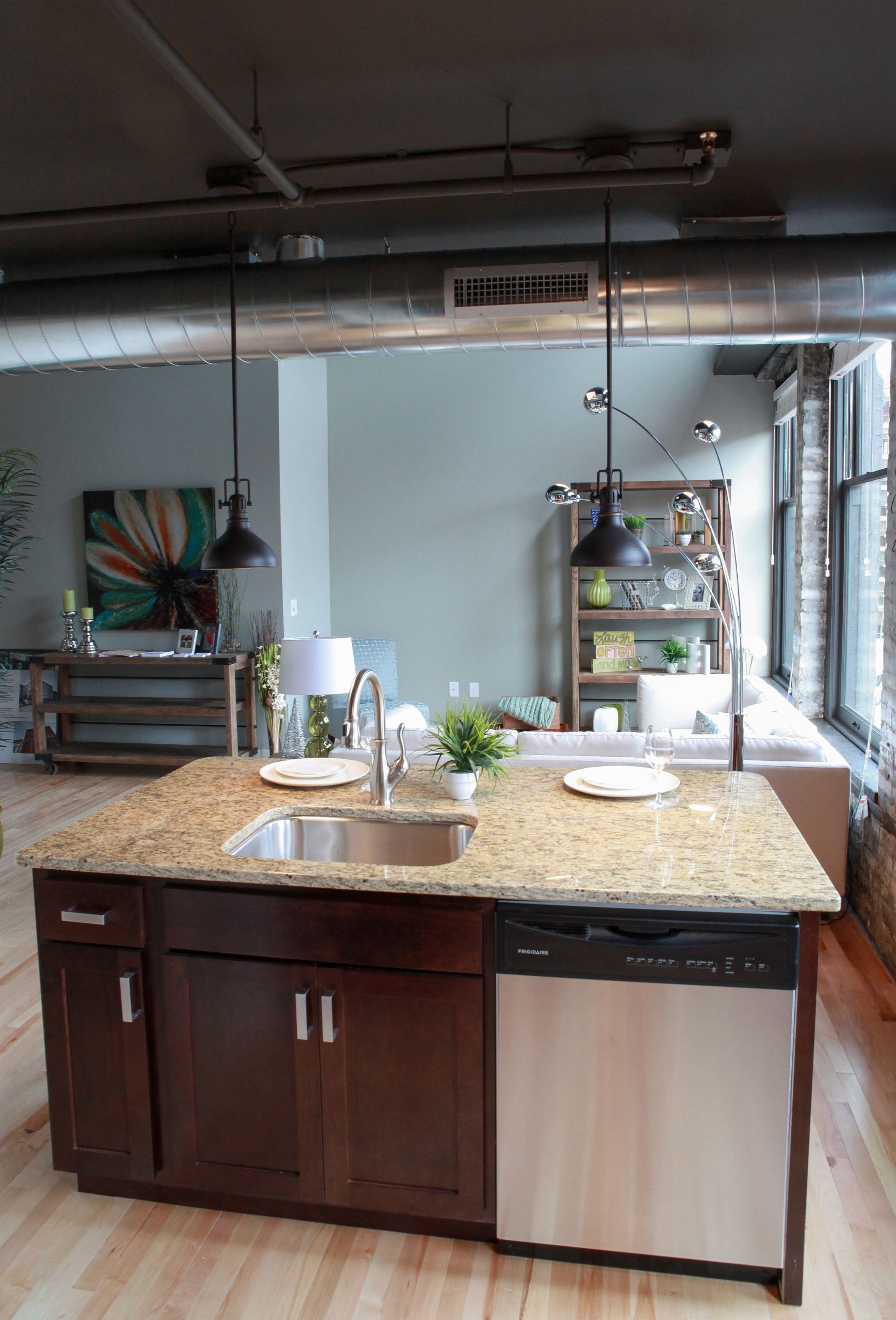 Kitchen island with sink and potted herbs in a bright modern kitchen