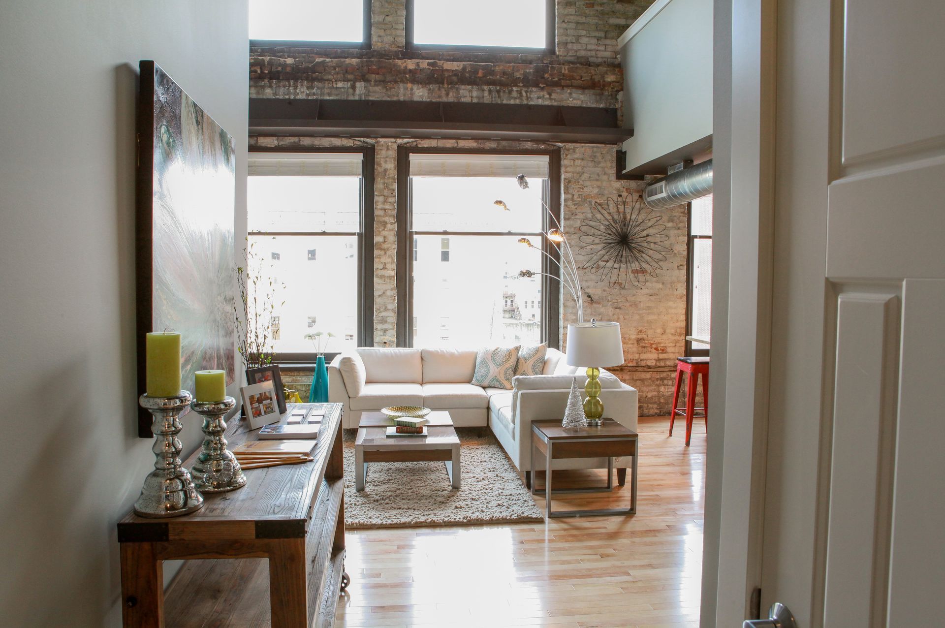 Bright modern living room with large windows, sofa, coffee table, and wooden floors