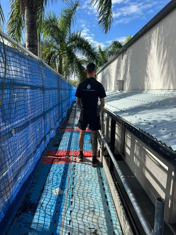 Man Standing in Scaffolding Beside a Roof — HFB Plumbing & Gas in Edmonton, QLD