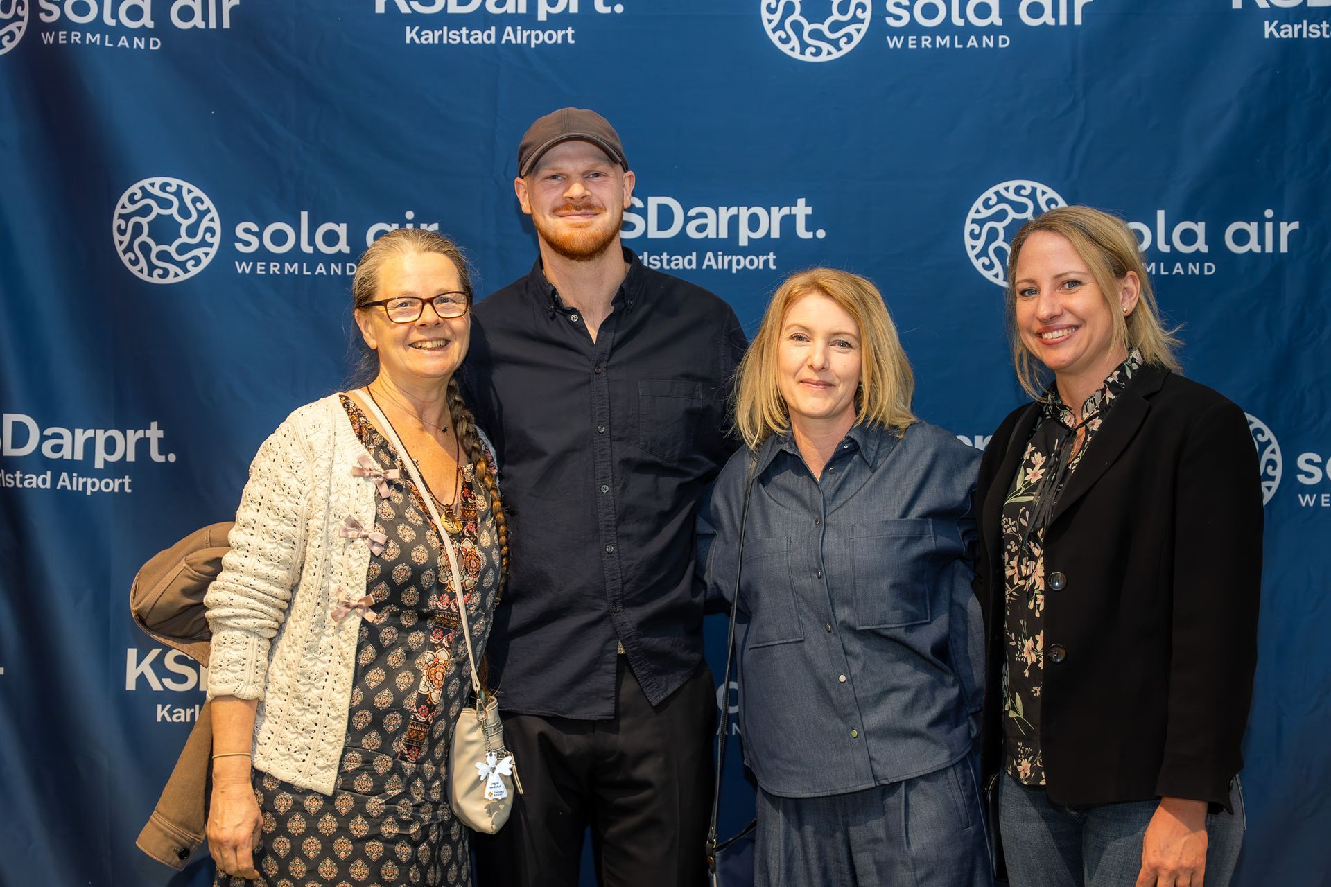 Fyra personer poserar framför en blå företagsbakgrund med Sola Air- och Darprt-logotyper.