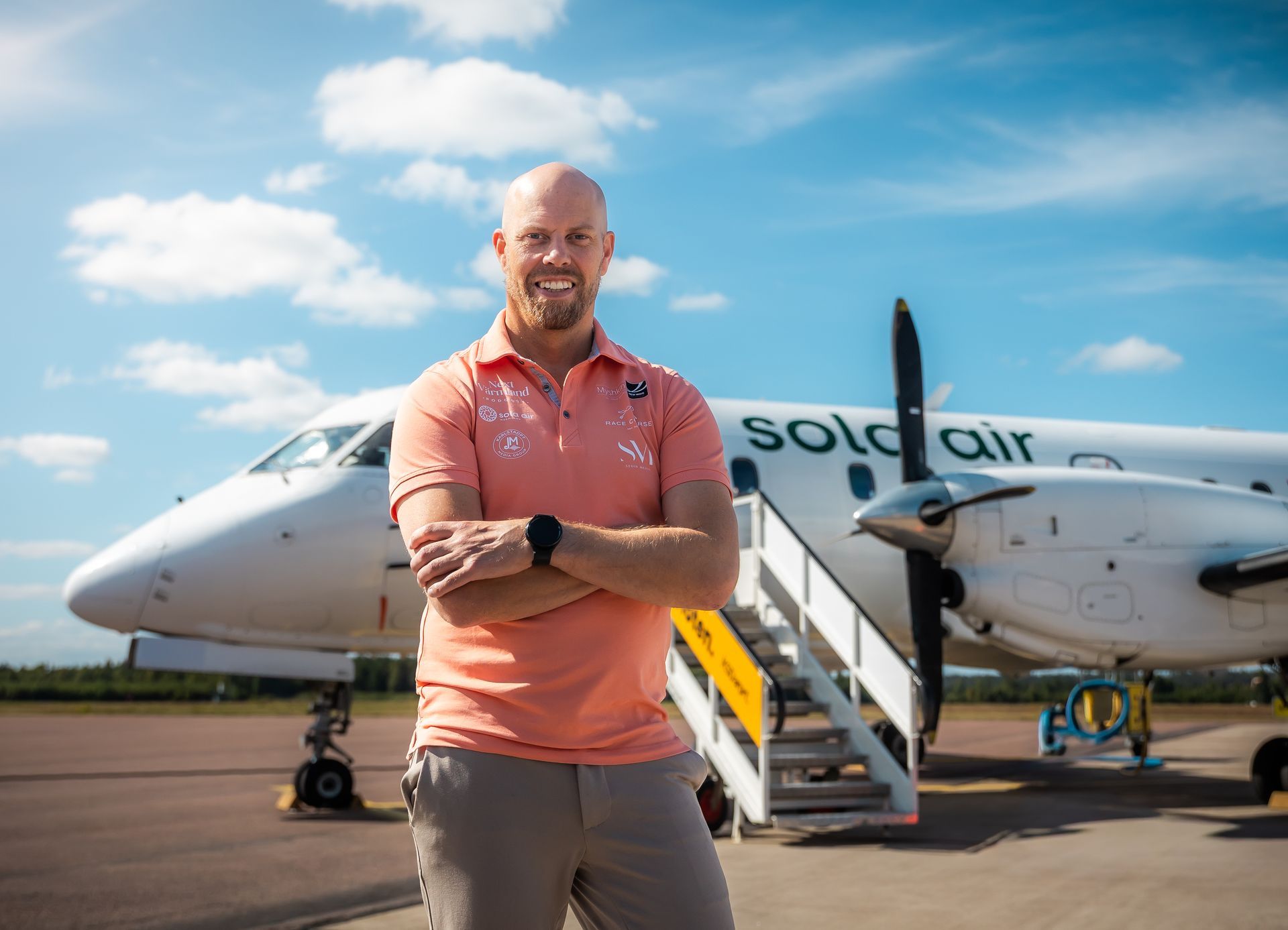 Flygplanets kabingång med en stående flygvärdinna och passagerare sittande under en UTGÅNGSskylt