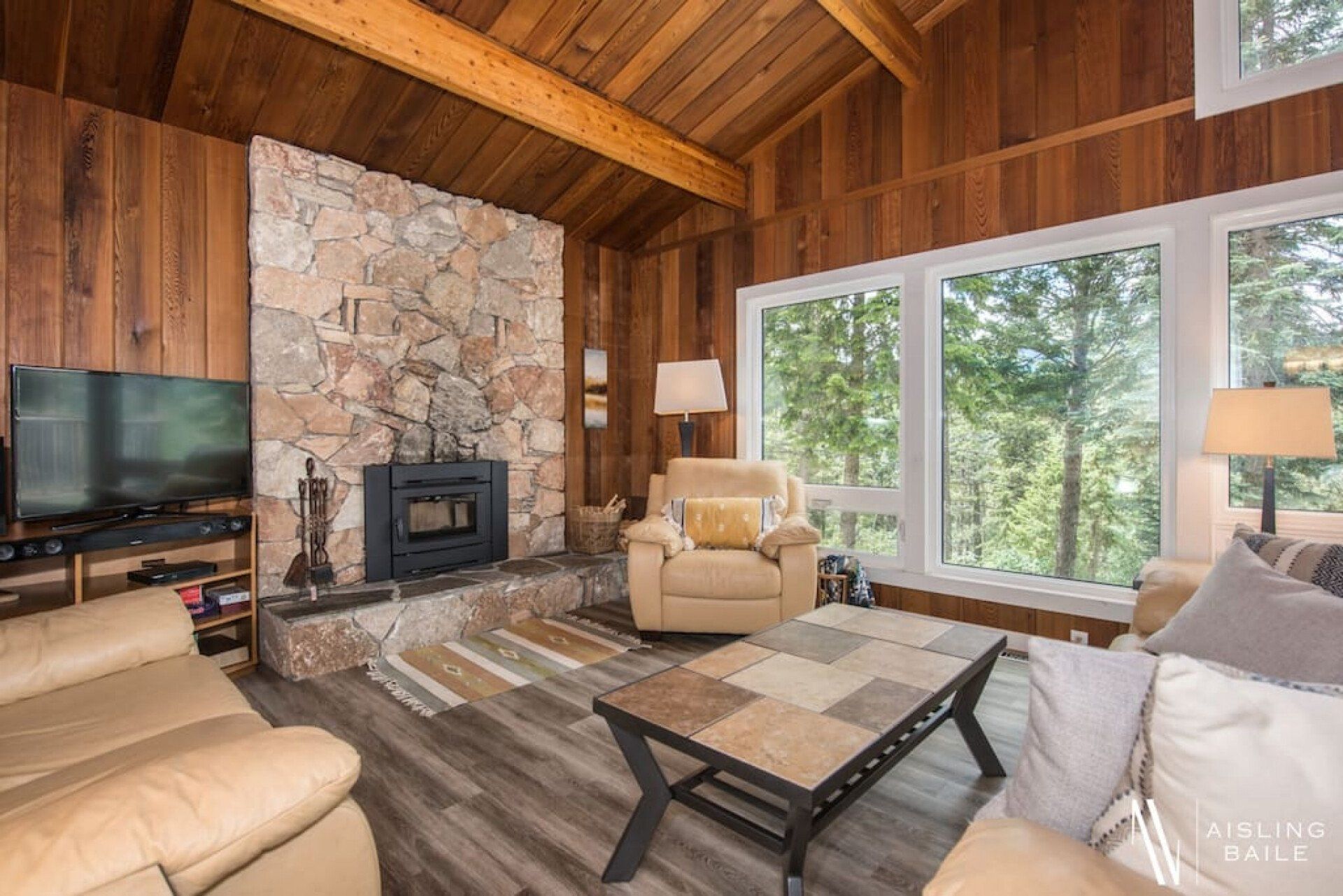 A living room with a fireplace , couch , chair and television.