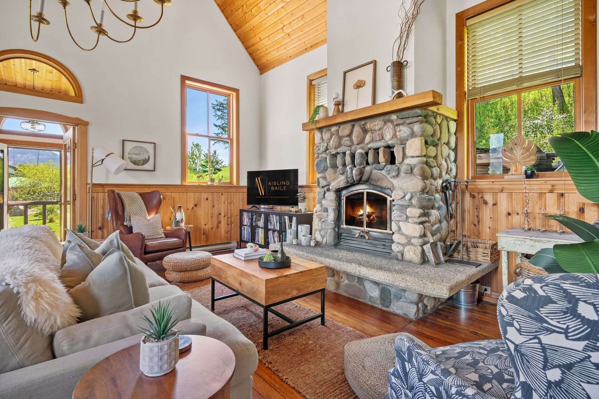 A living room with a stone fireplace and a couch.