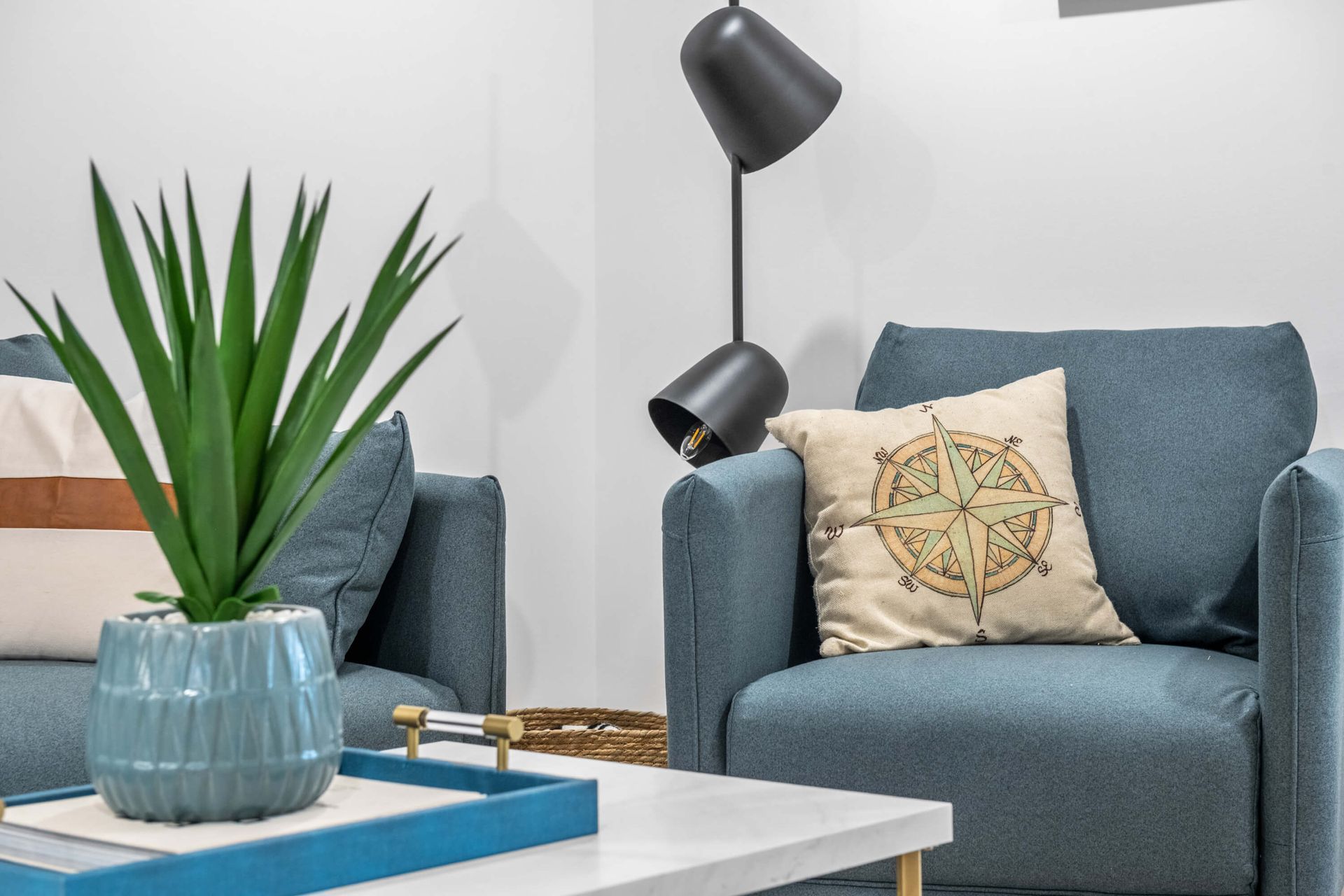 A living room with two chairs , a coffee table , and a lamp.