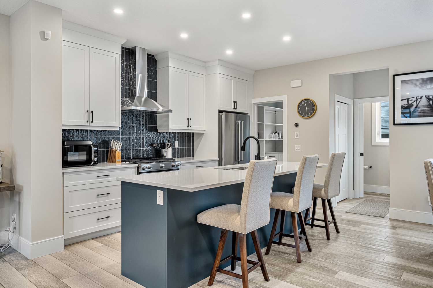 A kitchen with white cabinets and a large island in the middle.