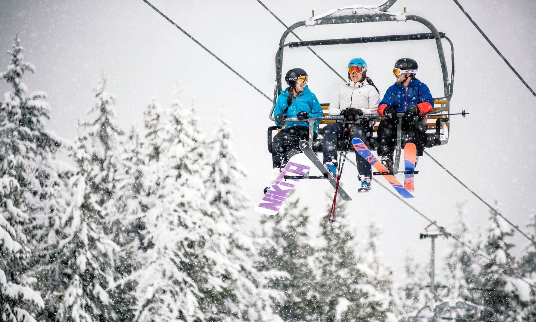 Three people on the main chairlift of Panorama, BC.