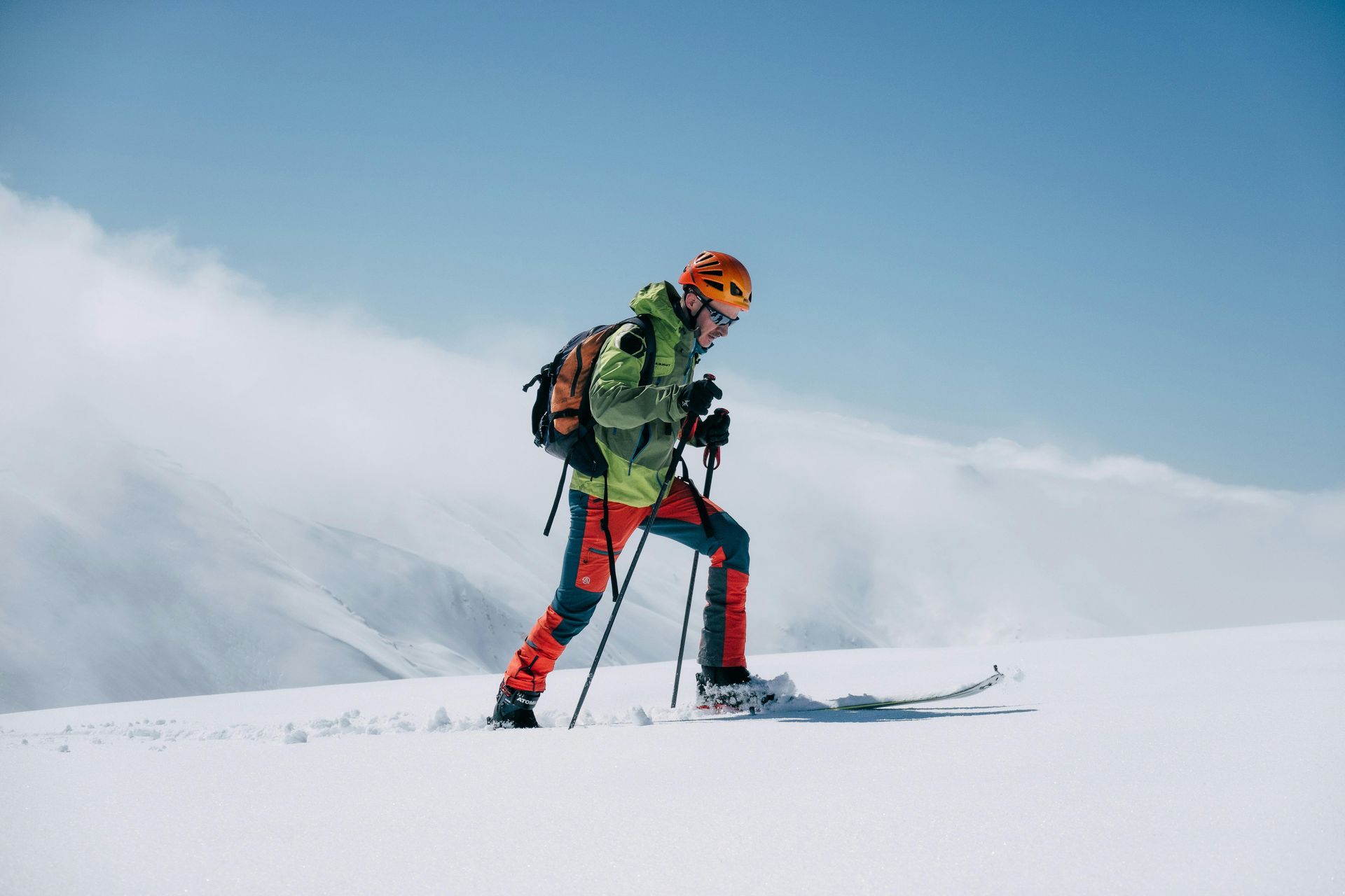 Person snowshoeing with poles through a snowy trail.