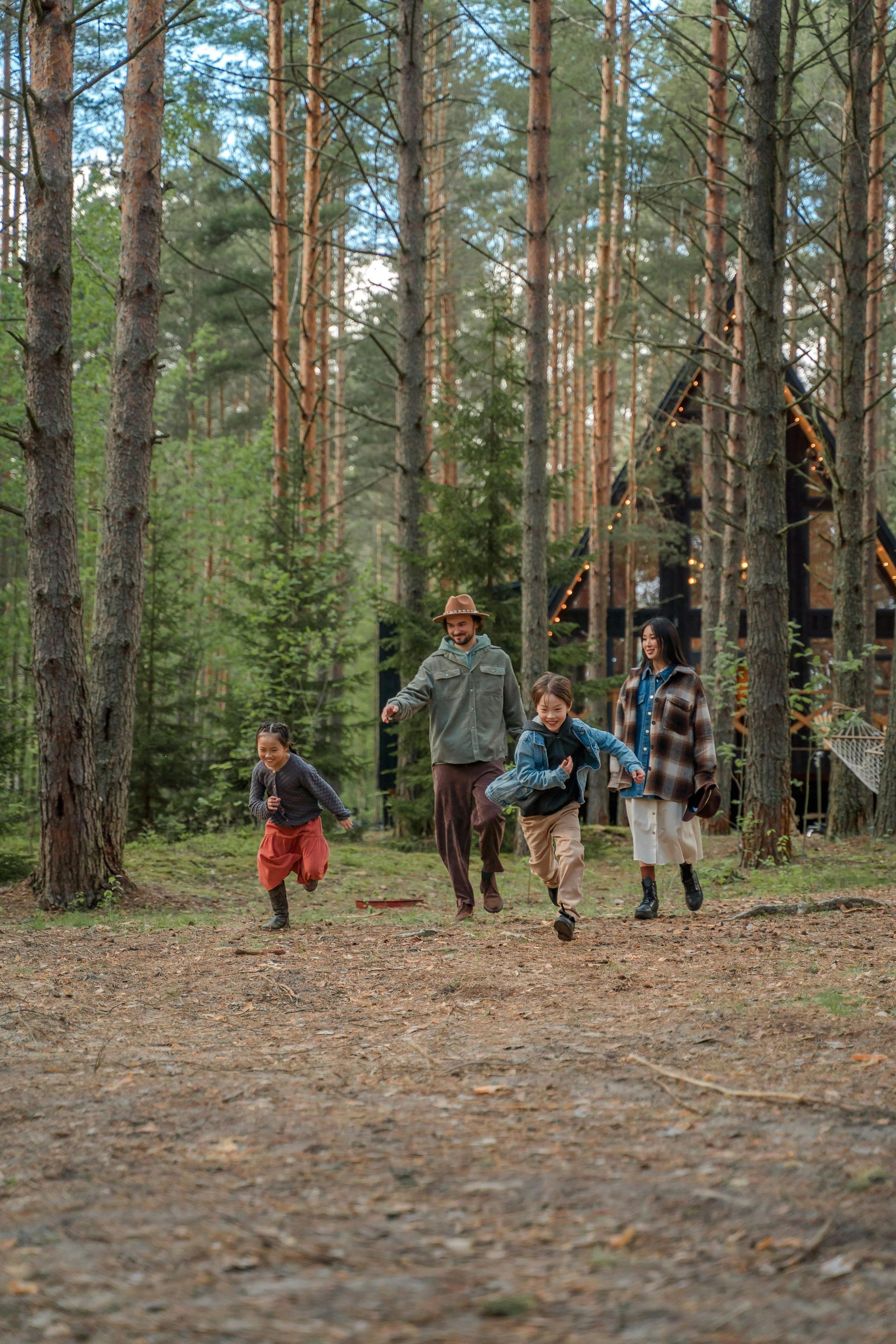 Family frolicking in the trees at a vacation rental cabin in BC, Canada.