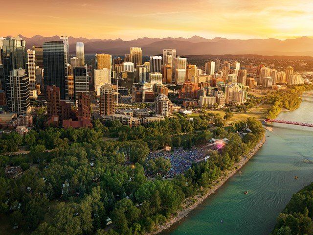 An aerial view of a city with a river and mountains in the background.