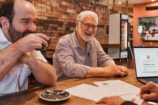 Man meeting with two male clients in a coffee show