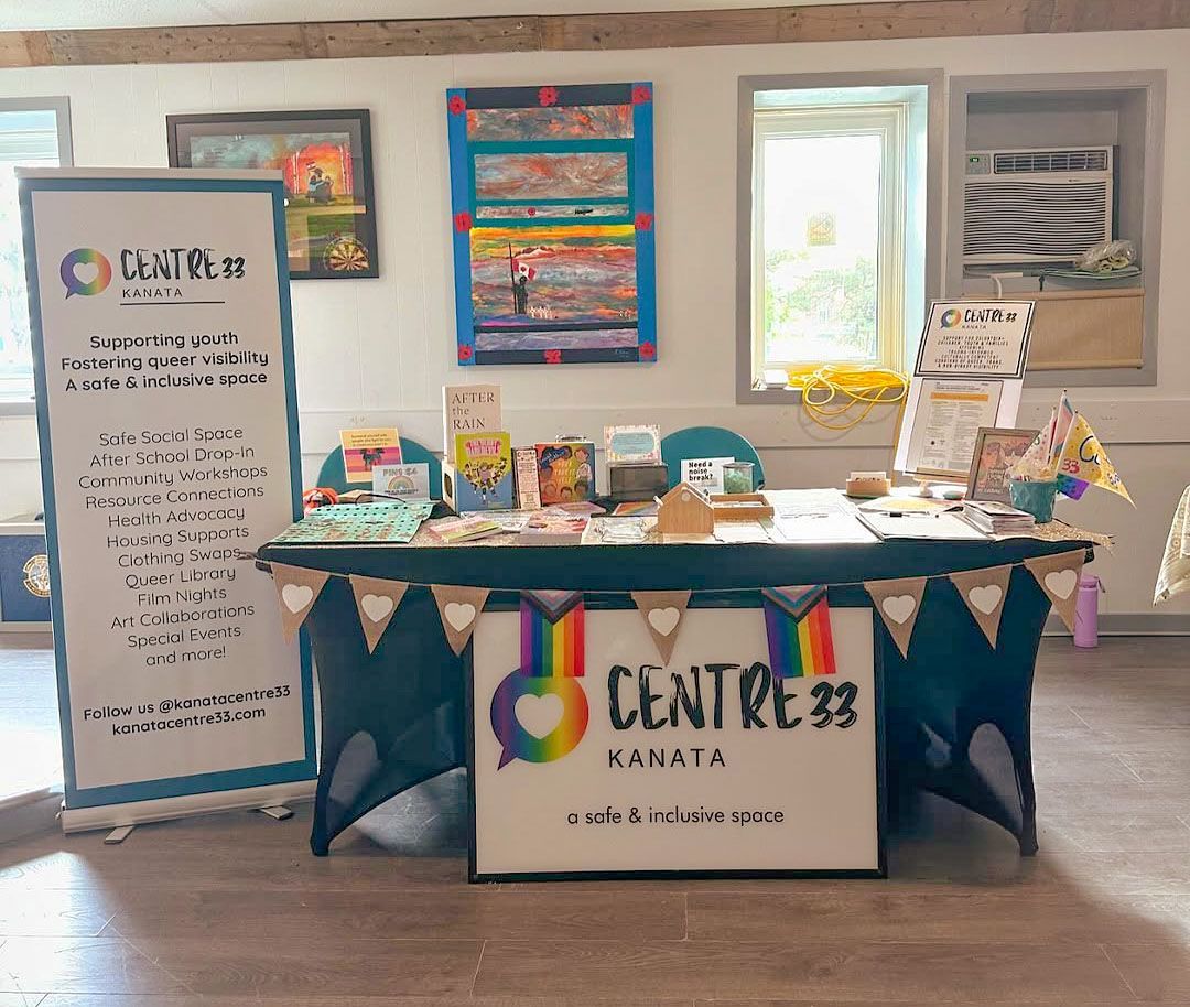 Resource table with colorful flyers and a sign reading “CENTRE” in a bright room