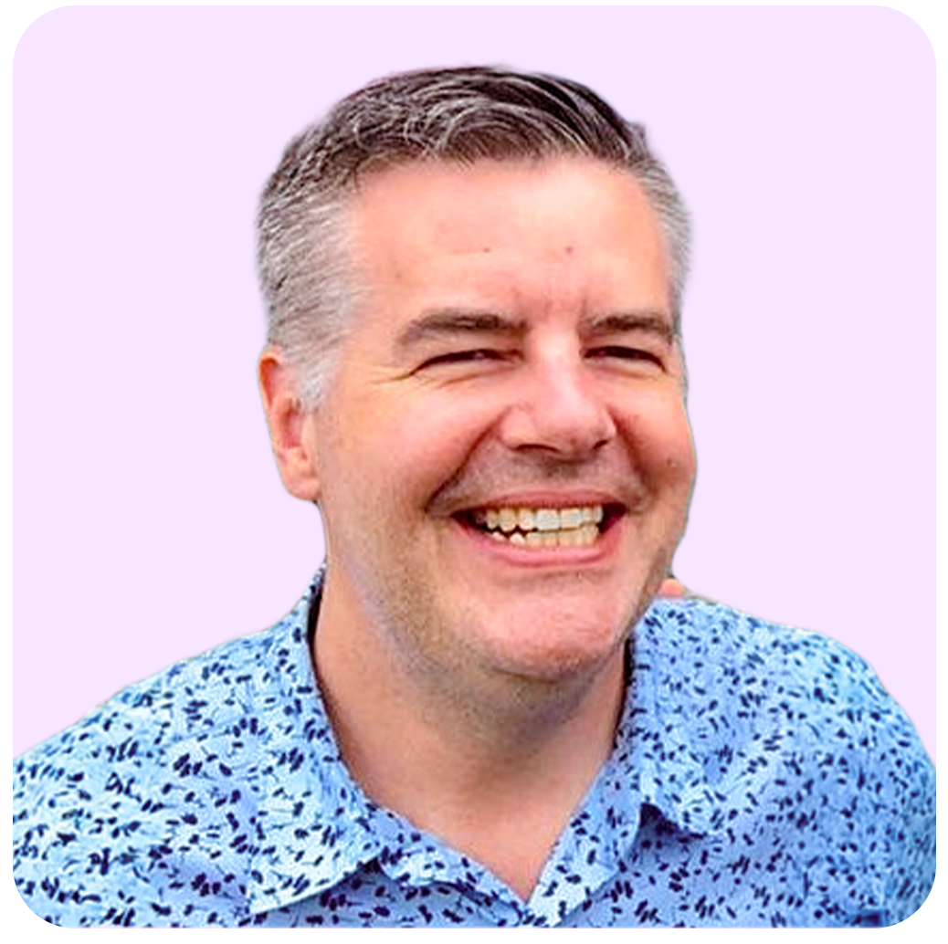 Smiling man in a blue patterned shirt against a light purple background