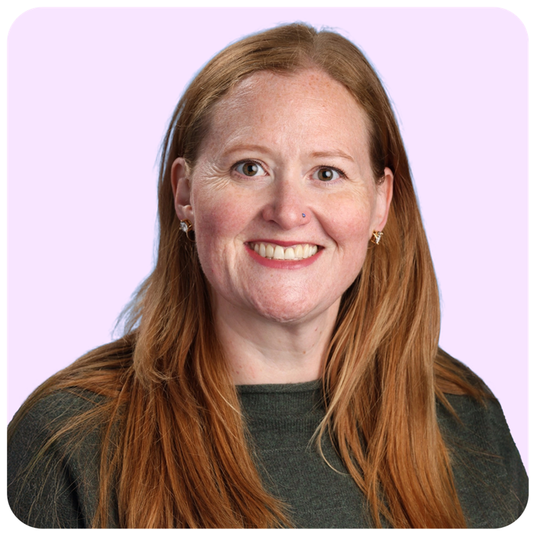 Smiling woman with long red hair against a light lavender background