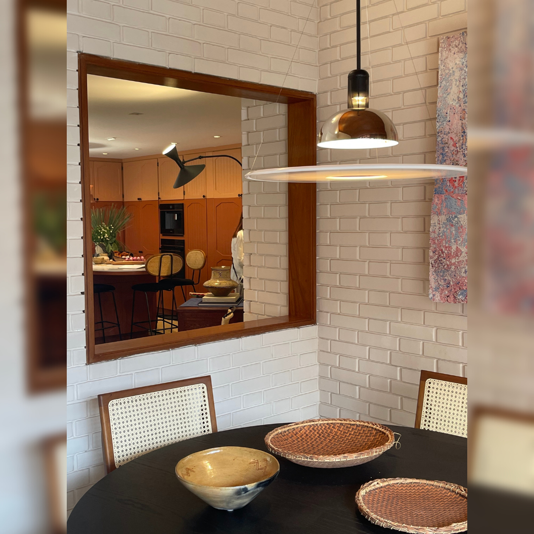 Un comedor con una mesa y sillas y un espejo.