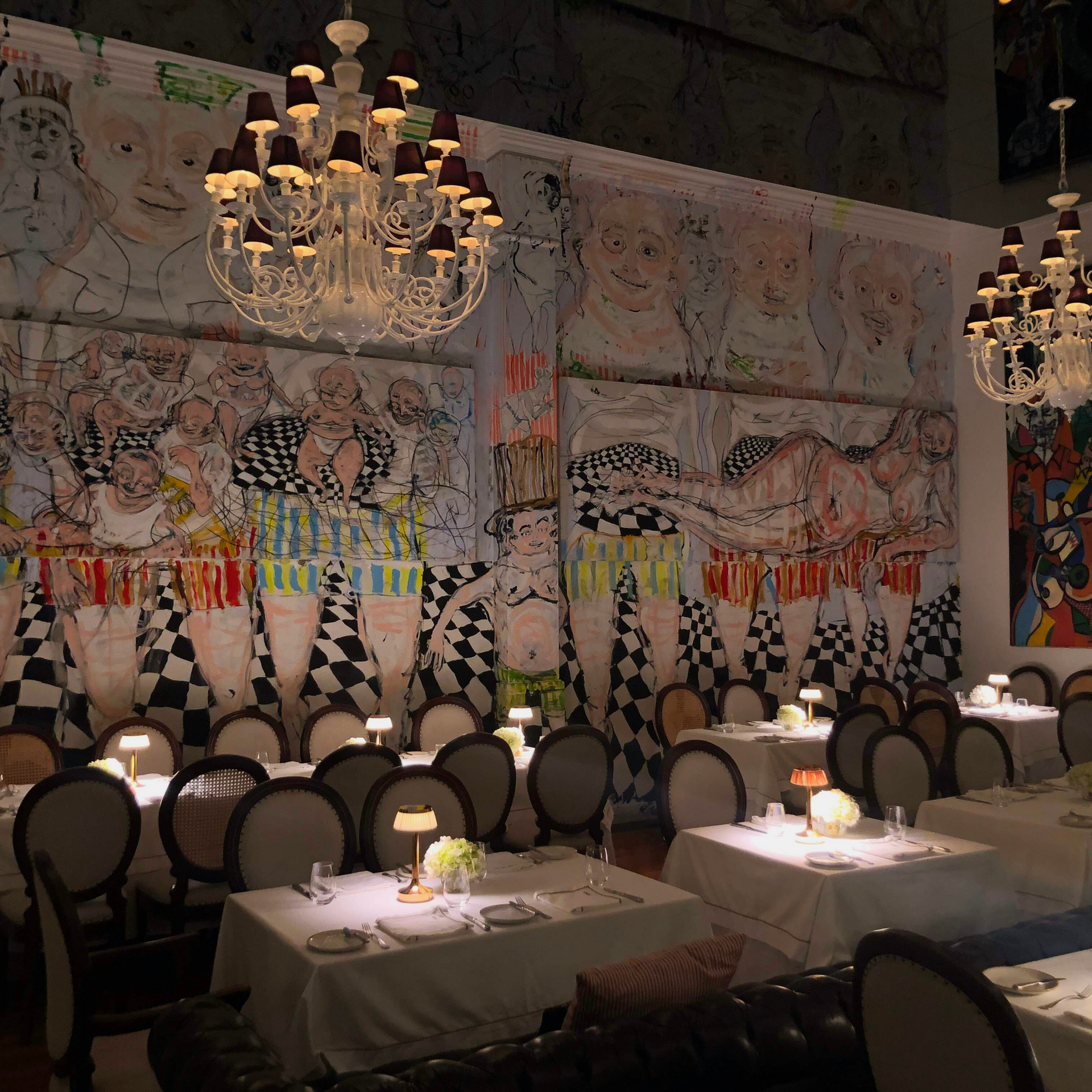 Un restaurante con mesas y sillas y un mural en la pared.
