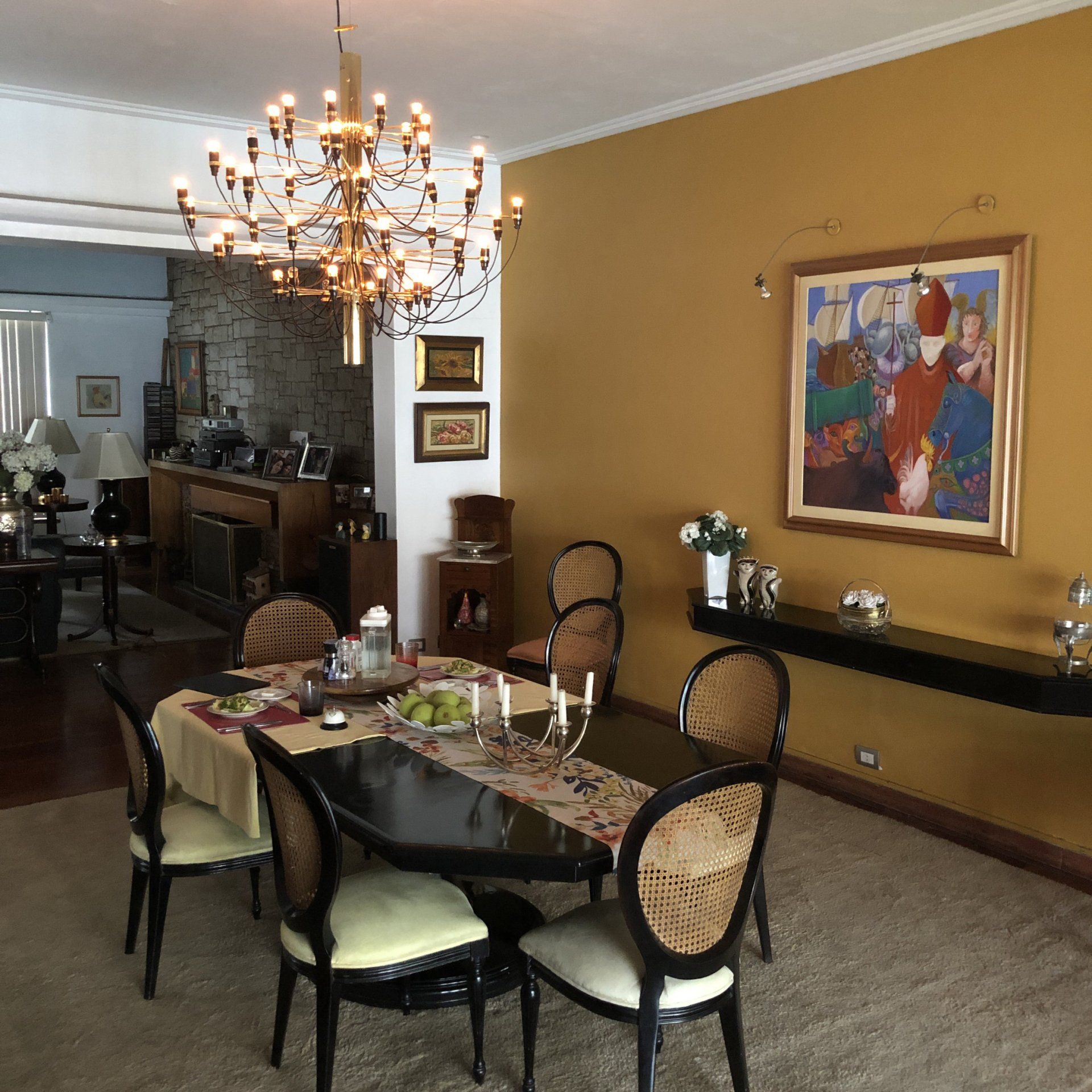 Un comedor con mesa, sillas y una lámpara de araña.