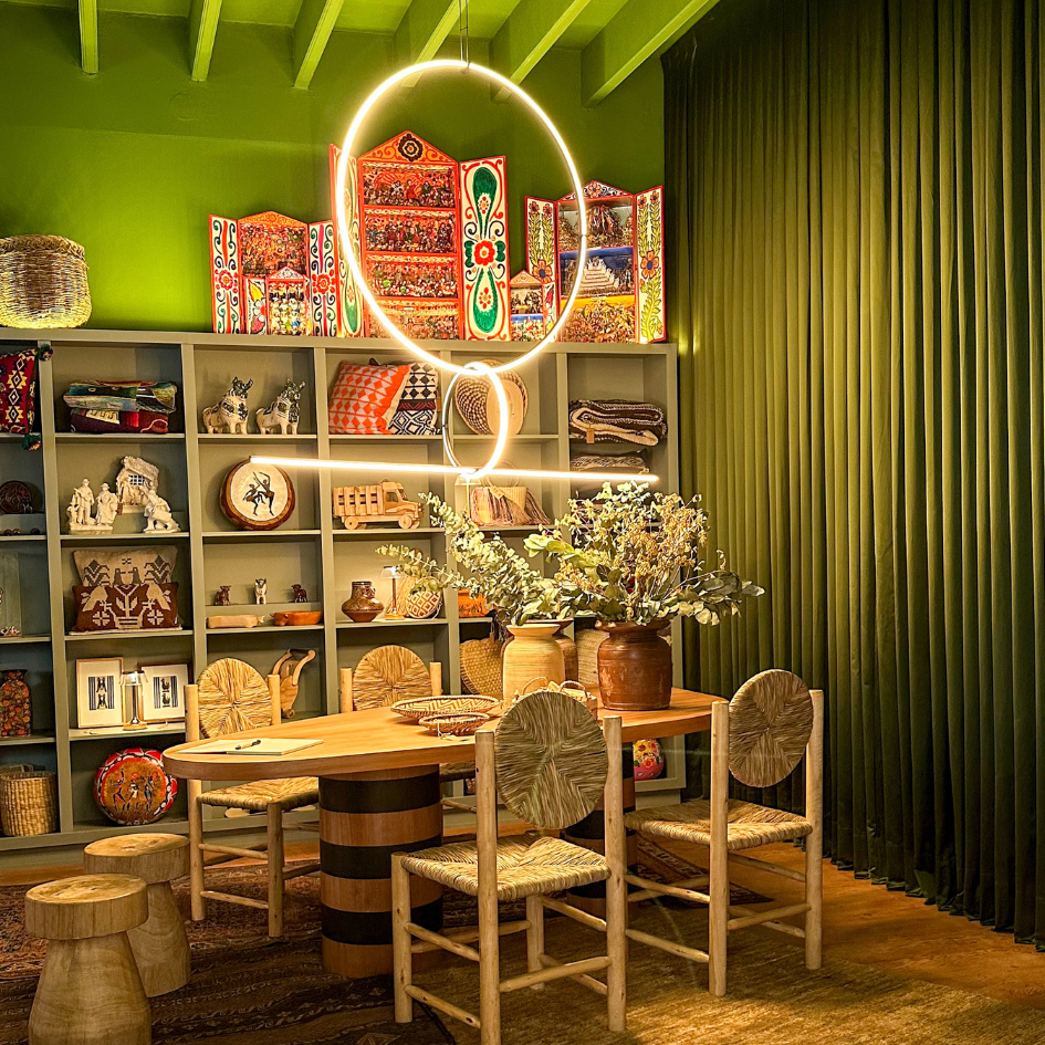 Un comedor con mesa y sillas y cortinas verdes.