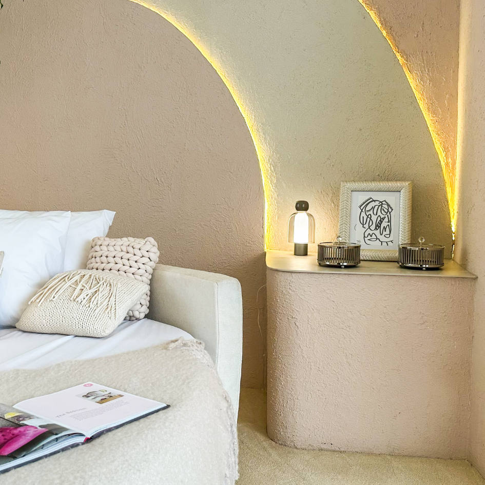 Un dormitorio con una cama y una mesa con velas encima.