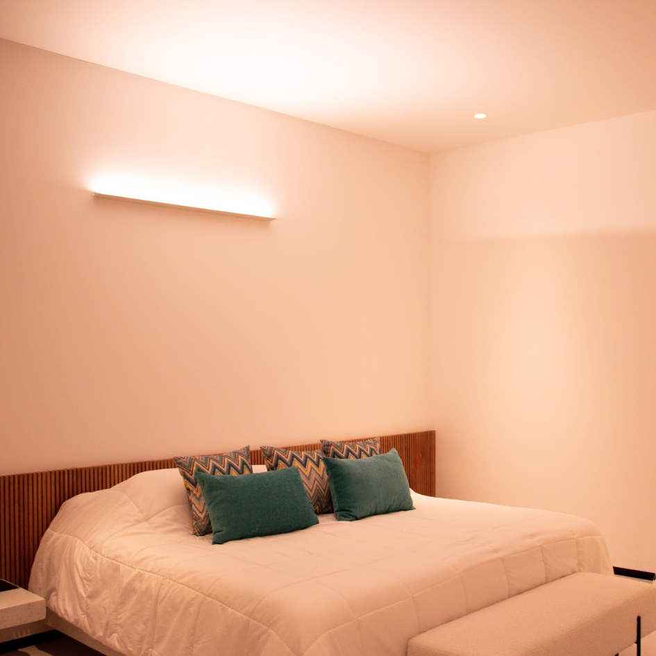 Un dormitorio con una cama king size y un banco.
