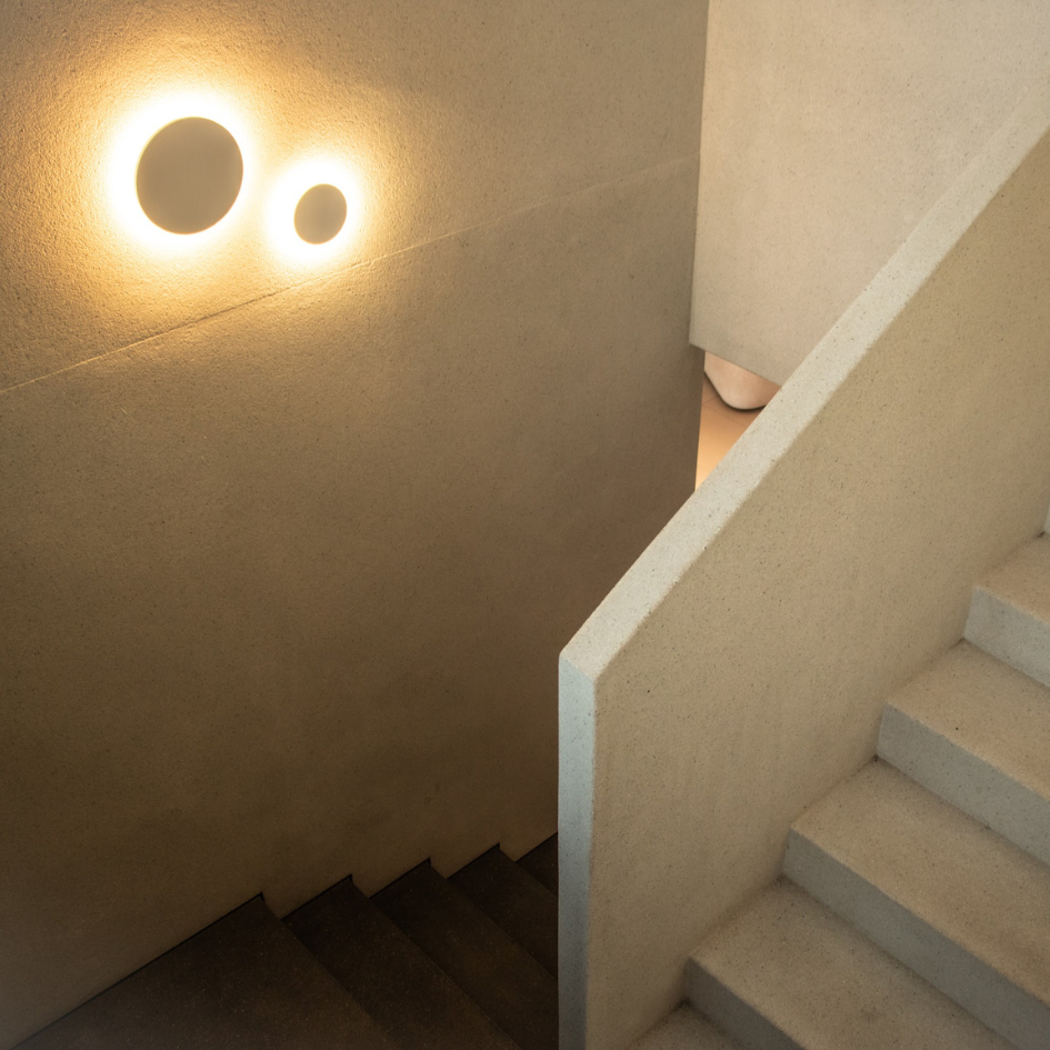 Una escalera con una luz en la pared encima.