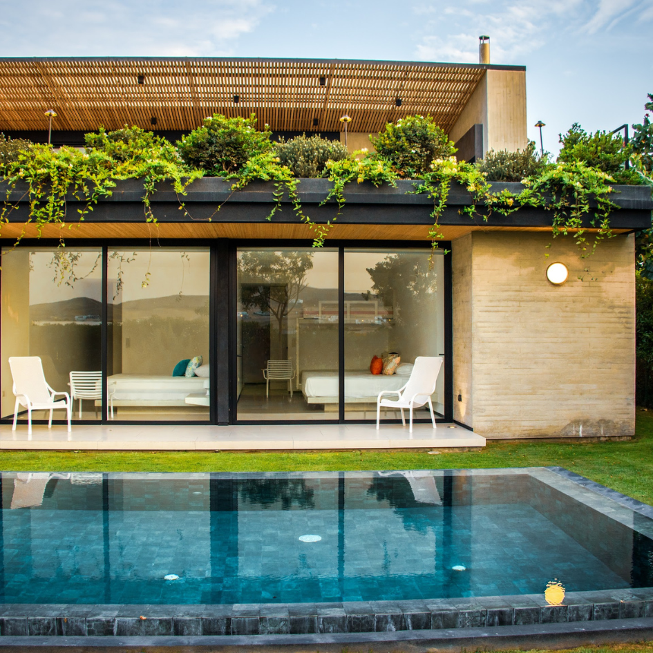 Una casa con una gran piscina en frente de ella.