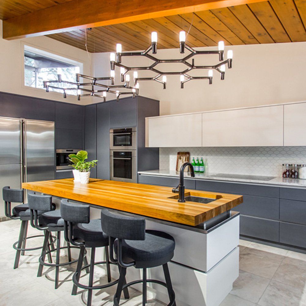 Una cocina con una gran mesa de madera y taburetes.