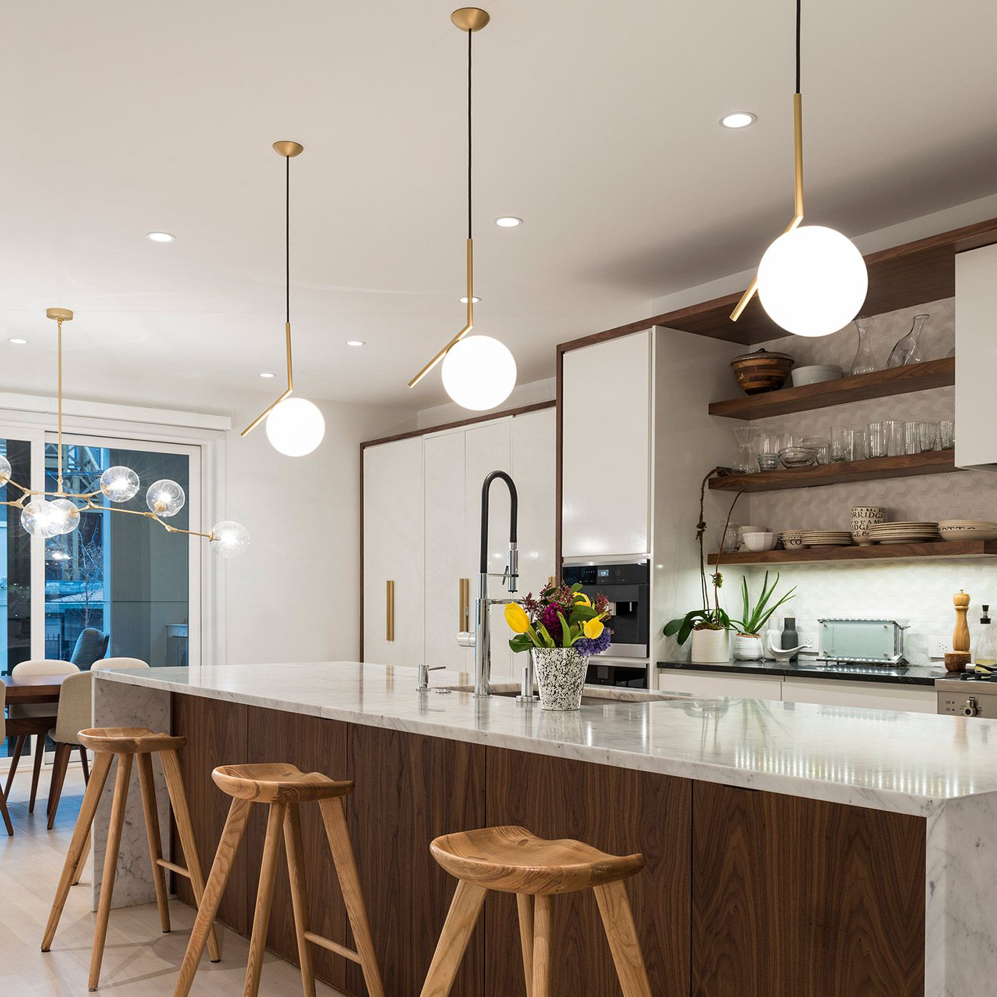 Una cocina con una gran isla y taburetes de madera.