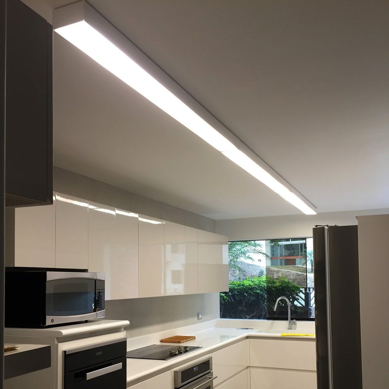 Una cocina con gabinetes blancos y una luz de techo.