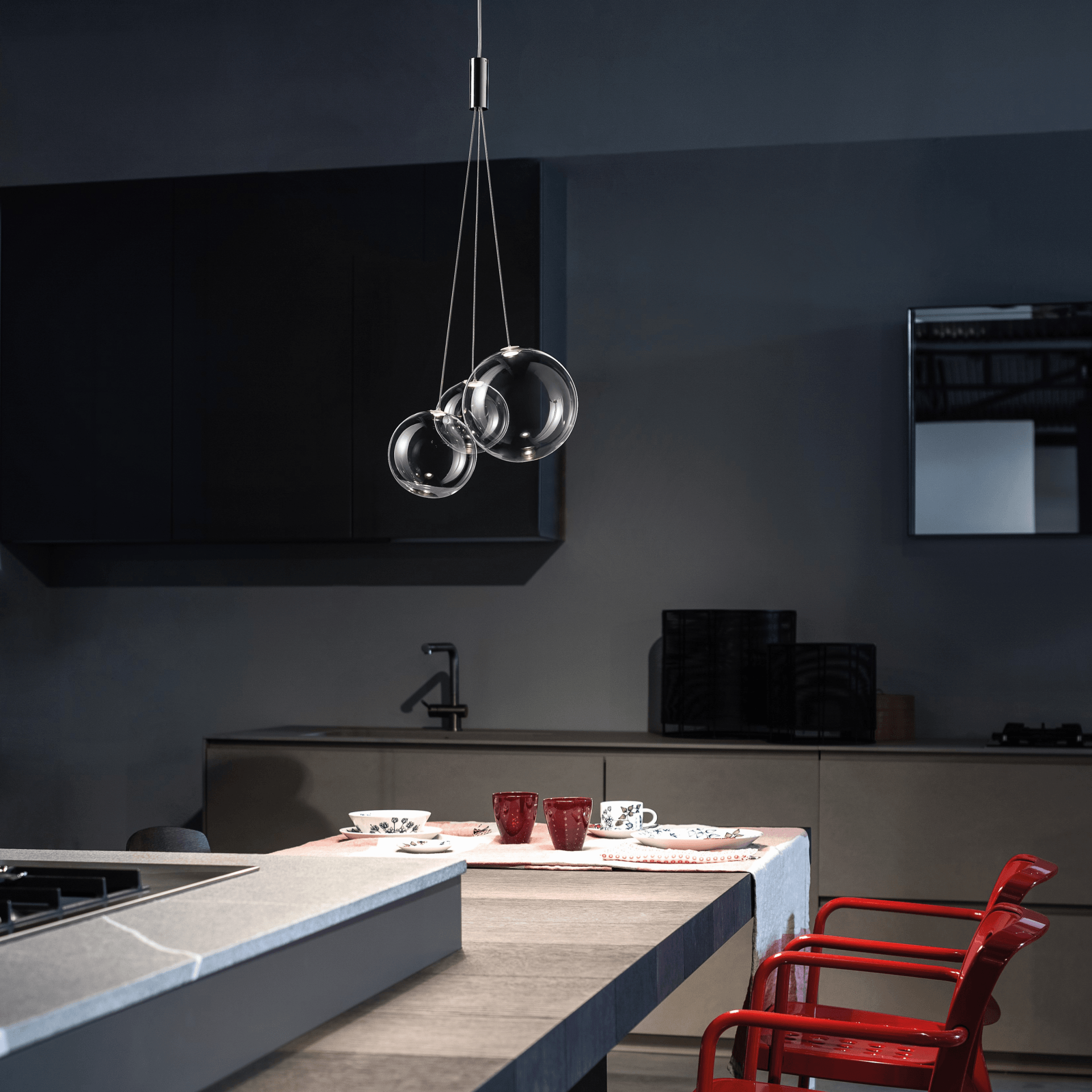 Una cocina con dos sillas rojas y una mesa.