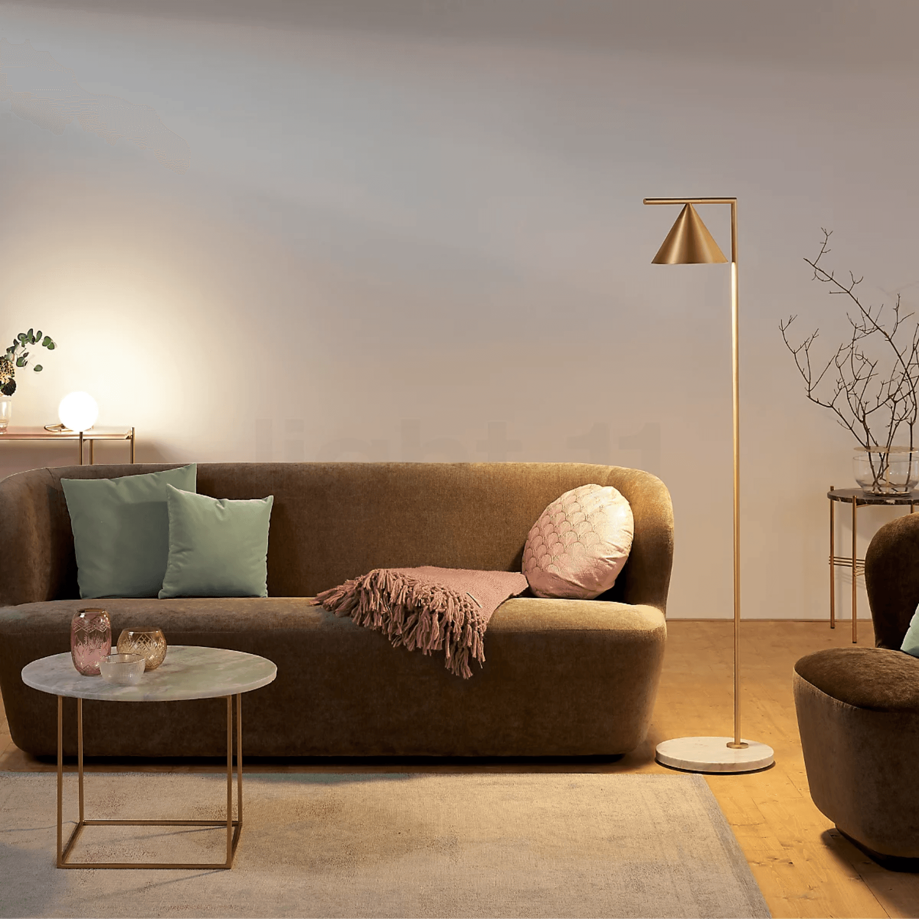Una sala de estar con un sofá, un sillón y una lámpara.