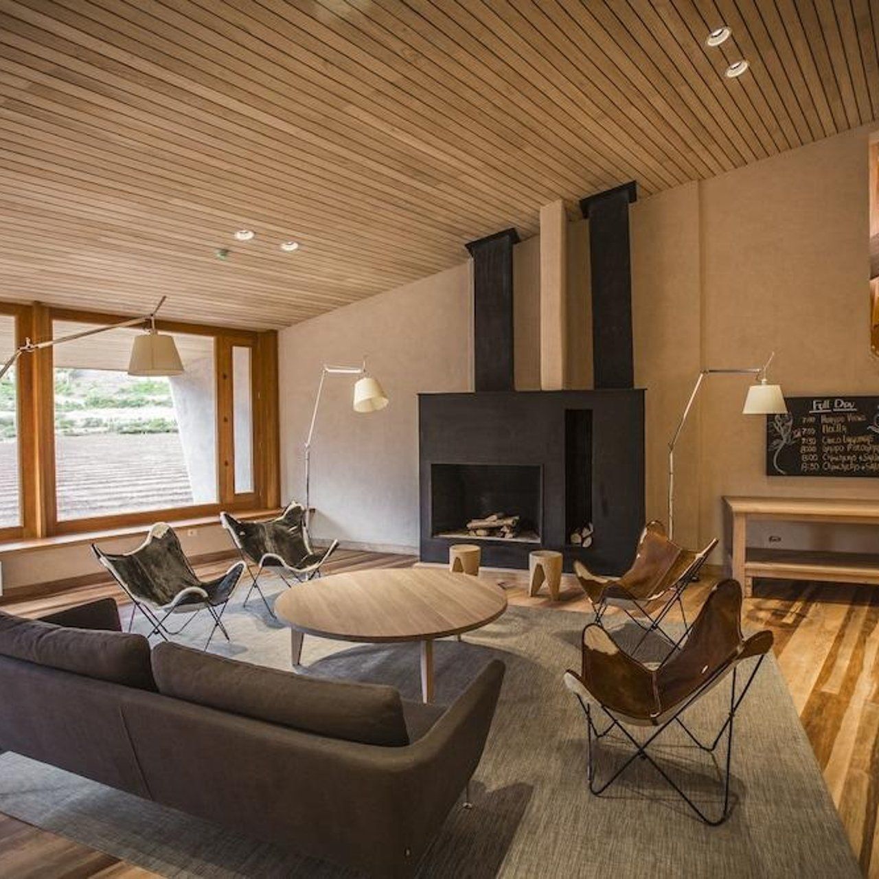 Una sala de estar con un sofá y sillas y una chimenea.