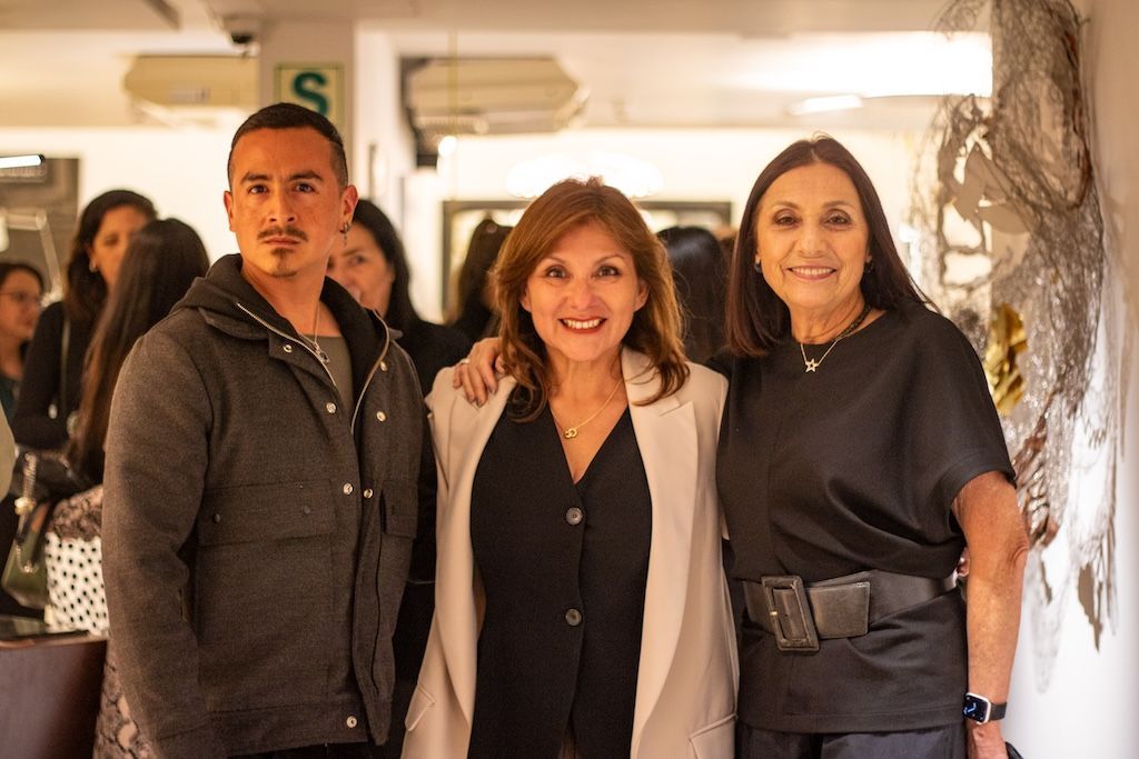 Un hombre y dos mujeres posan juntos para una fotografía.