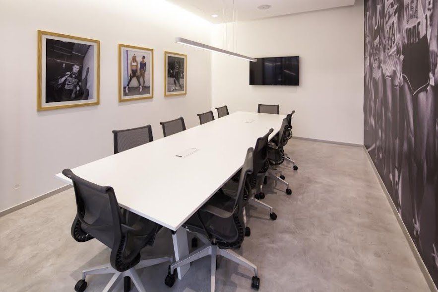 Una sala de conferencias con una mesa larga y sillas.