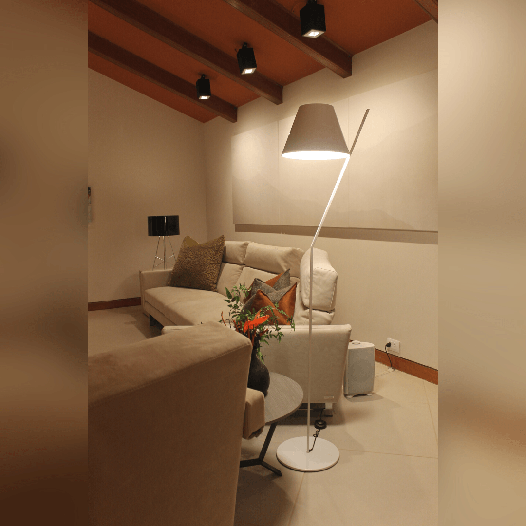Una sala de estar con un sofá y una lámpara.