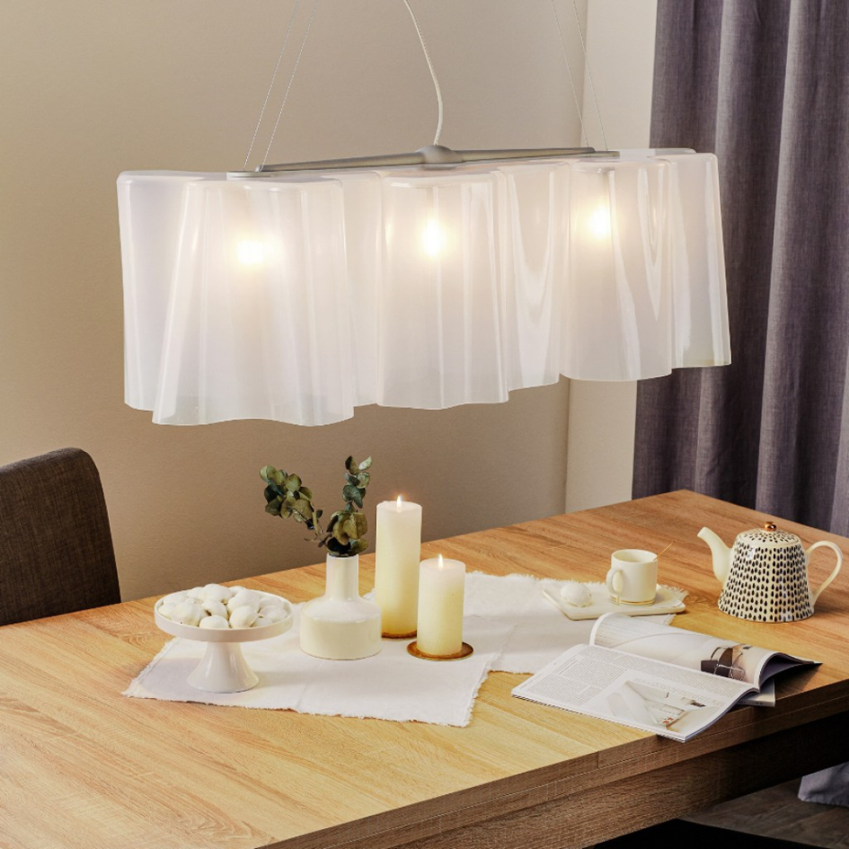 Una mesa de comedor con velas y una lámpara colgando del techo.