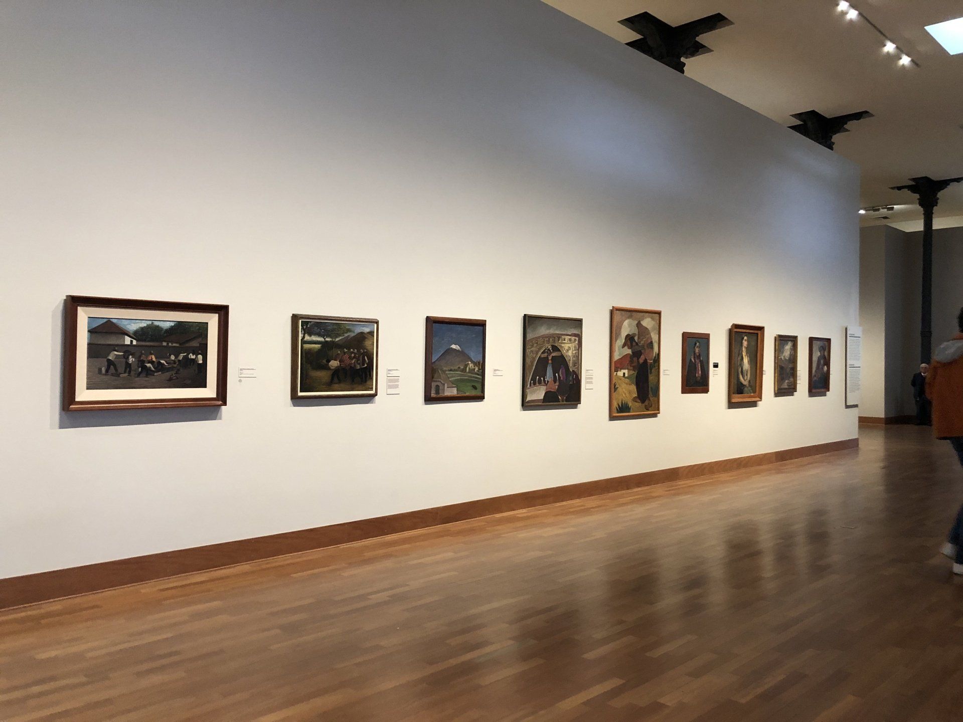 Una fila de pinturas en una pared de un museo.