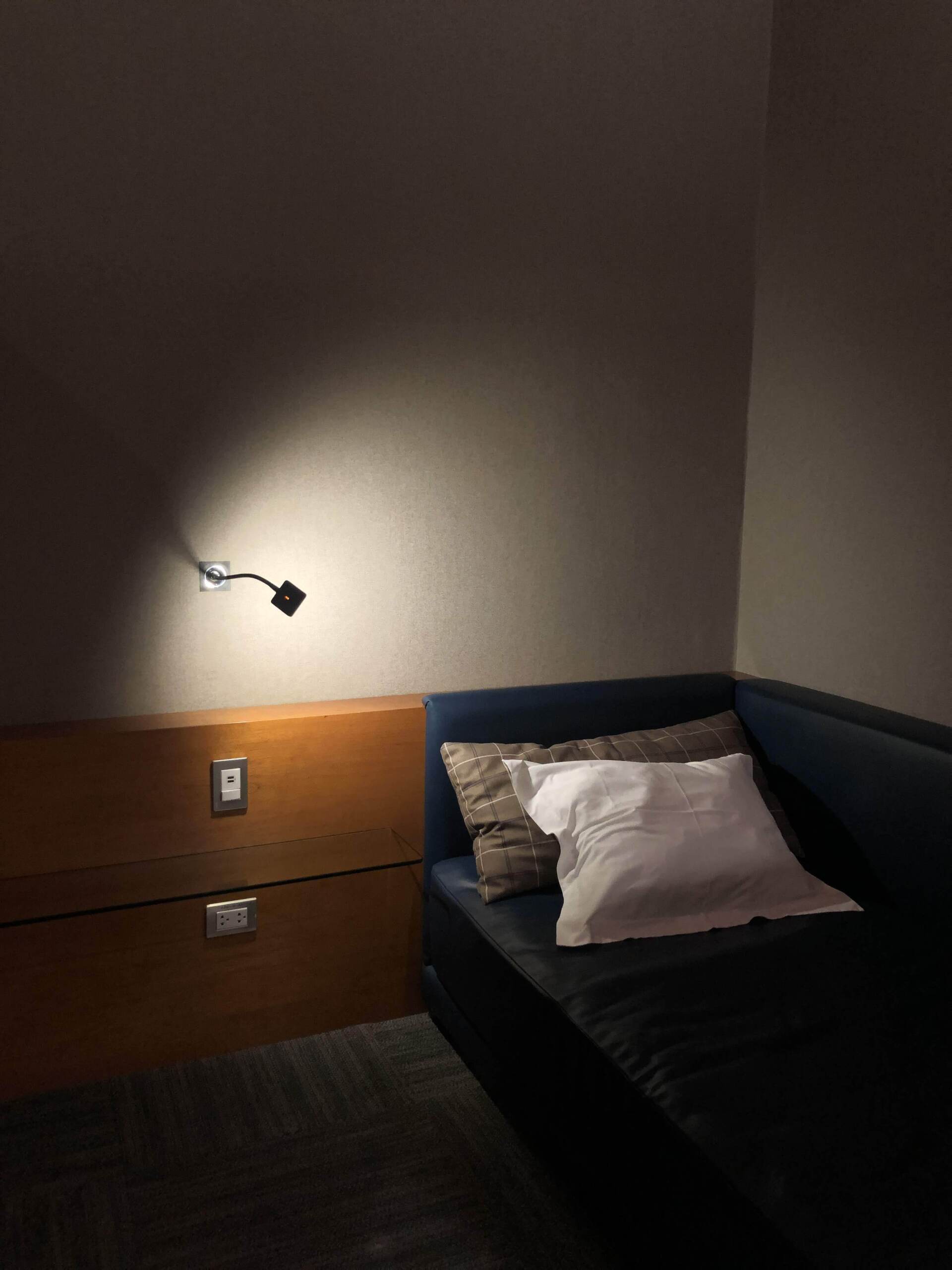 Una habitación oscura con un sofá y dos almohadas.
