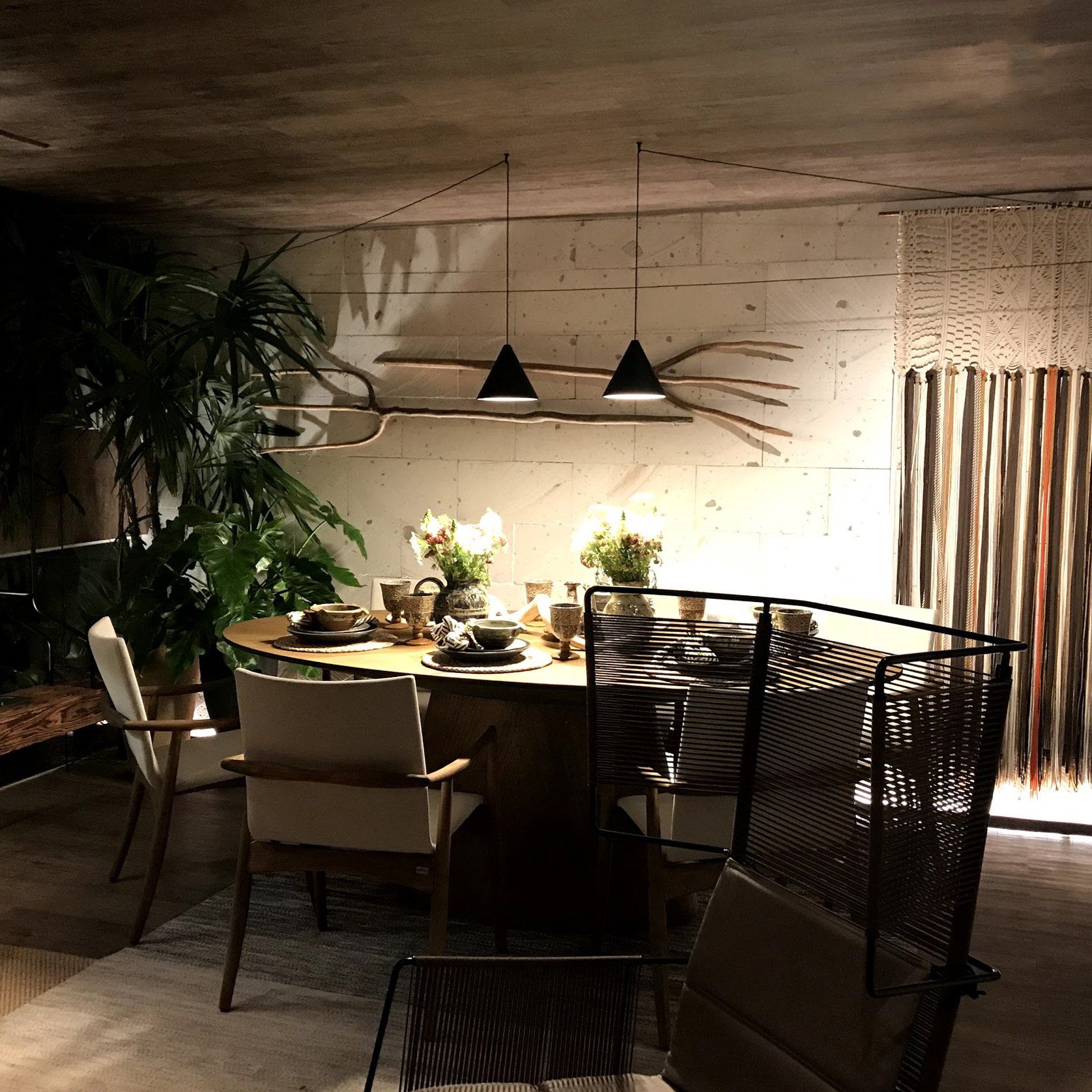 Un comedor con mesa y sillas por la noche.