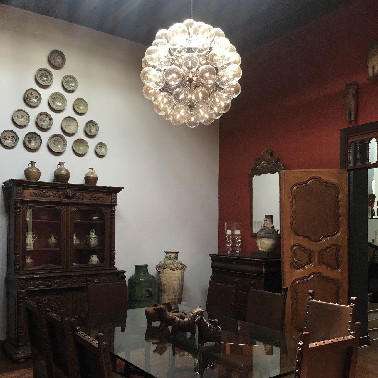 Un comedor con mesa, sillas y platos en la pared.